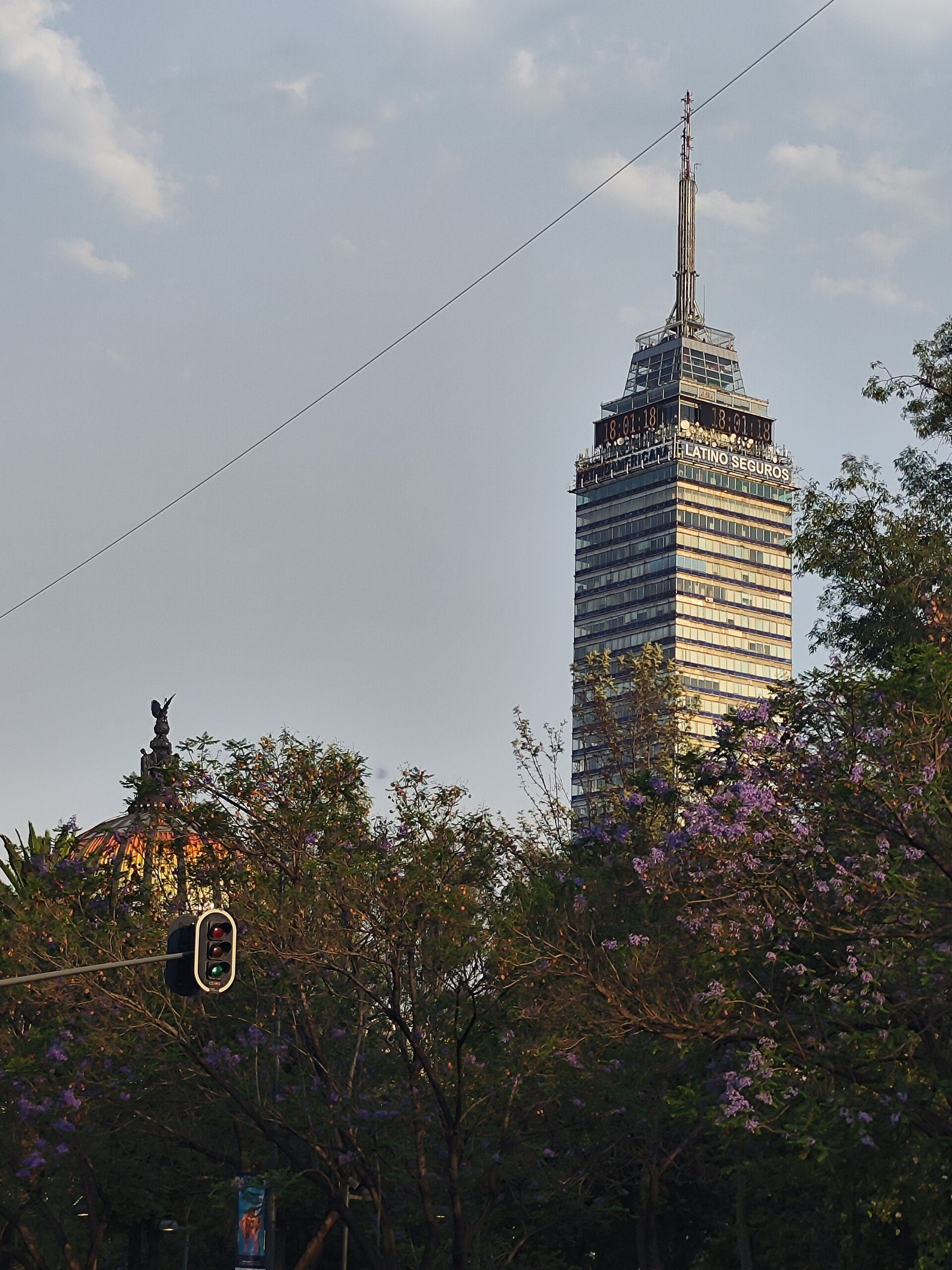 Alt text: "Cityscape view from a modern hotel room with large windows and balcony.