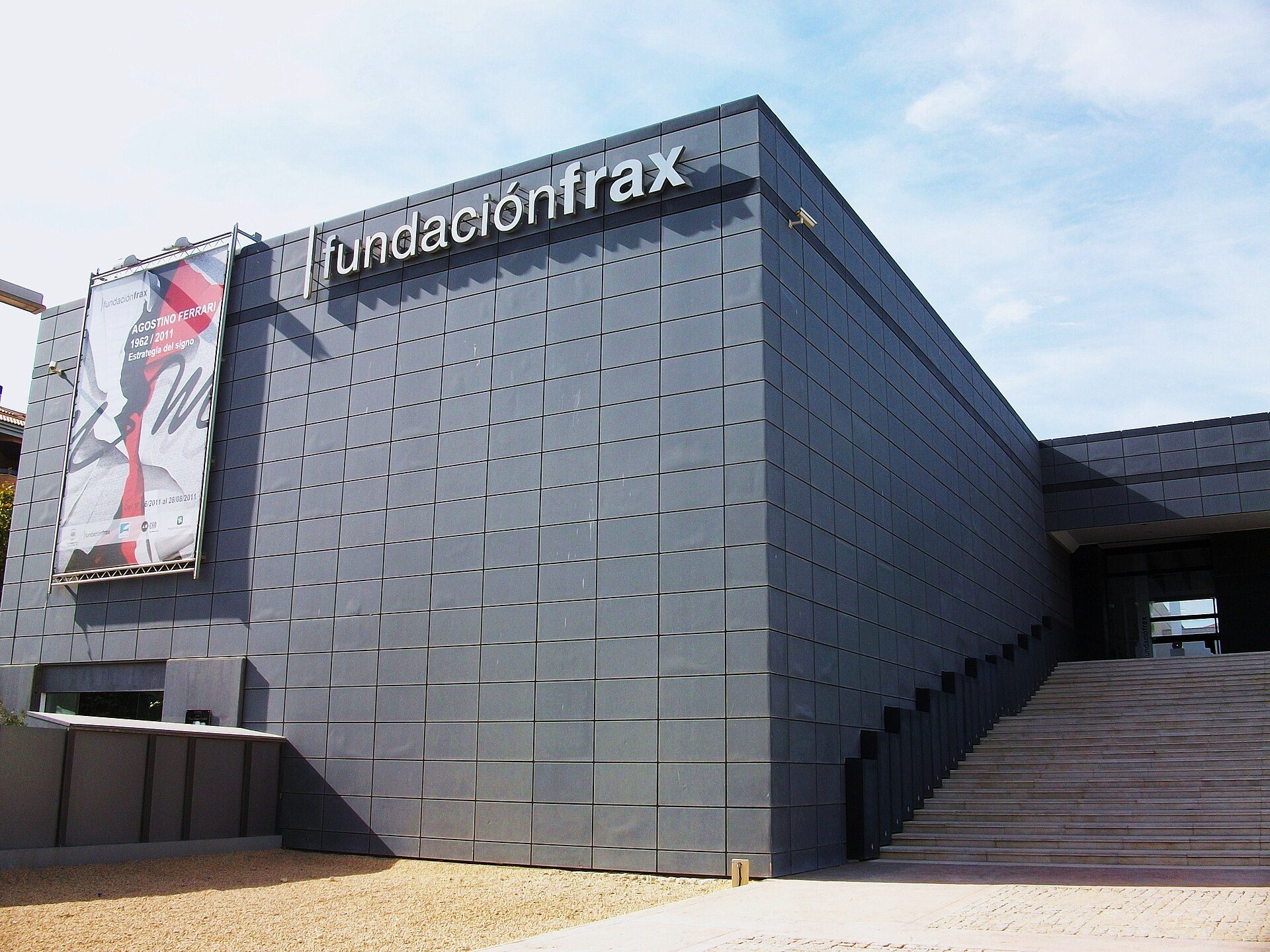 Modern building with "fundación frax" sign, large windows, and staircase entrance.