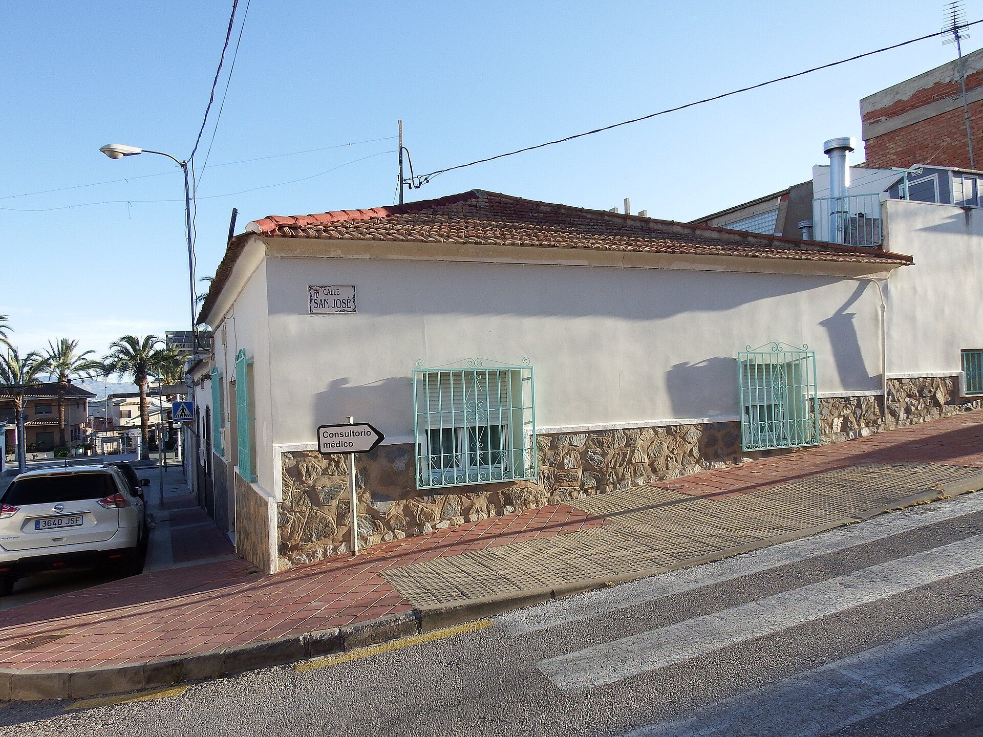 Small, cozy room with a view of the street, featuring a tiled roof and stone base.