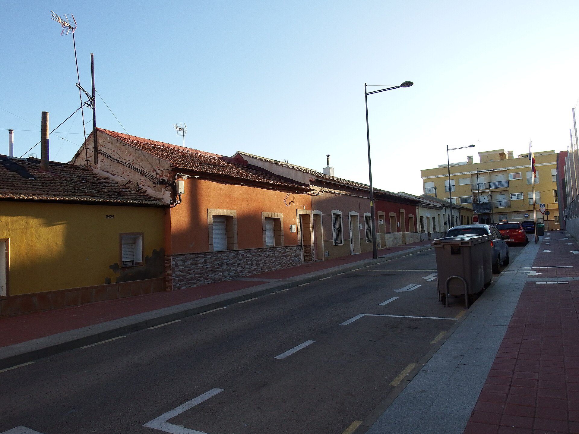 Alt text: Two-story residential building with a street view, featuring a mix of stone and painted walls.