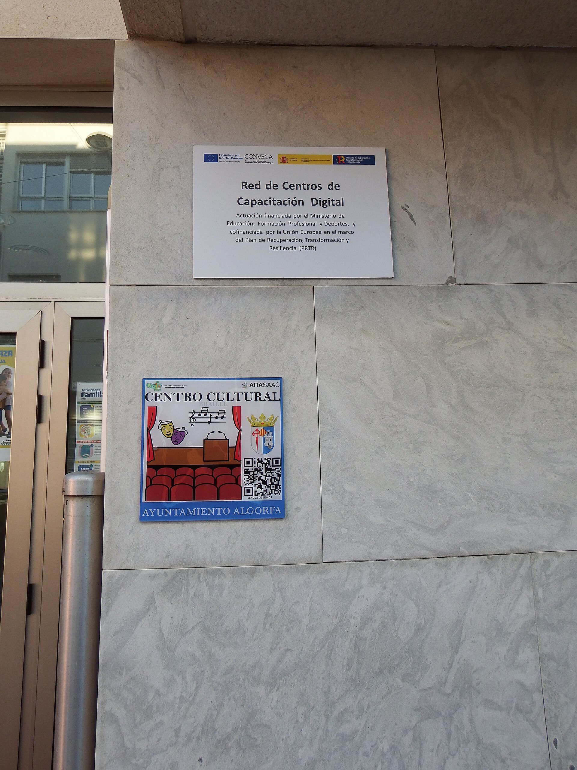 Sign for "Red de Centros de Capacitación Digital" and "Centro Cultural" with QR code and seating illustration.