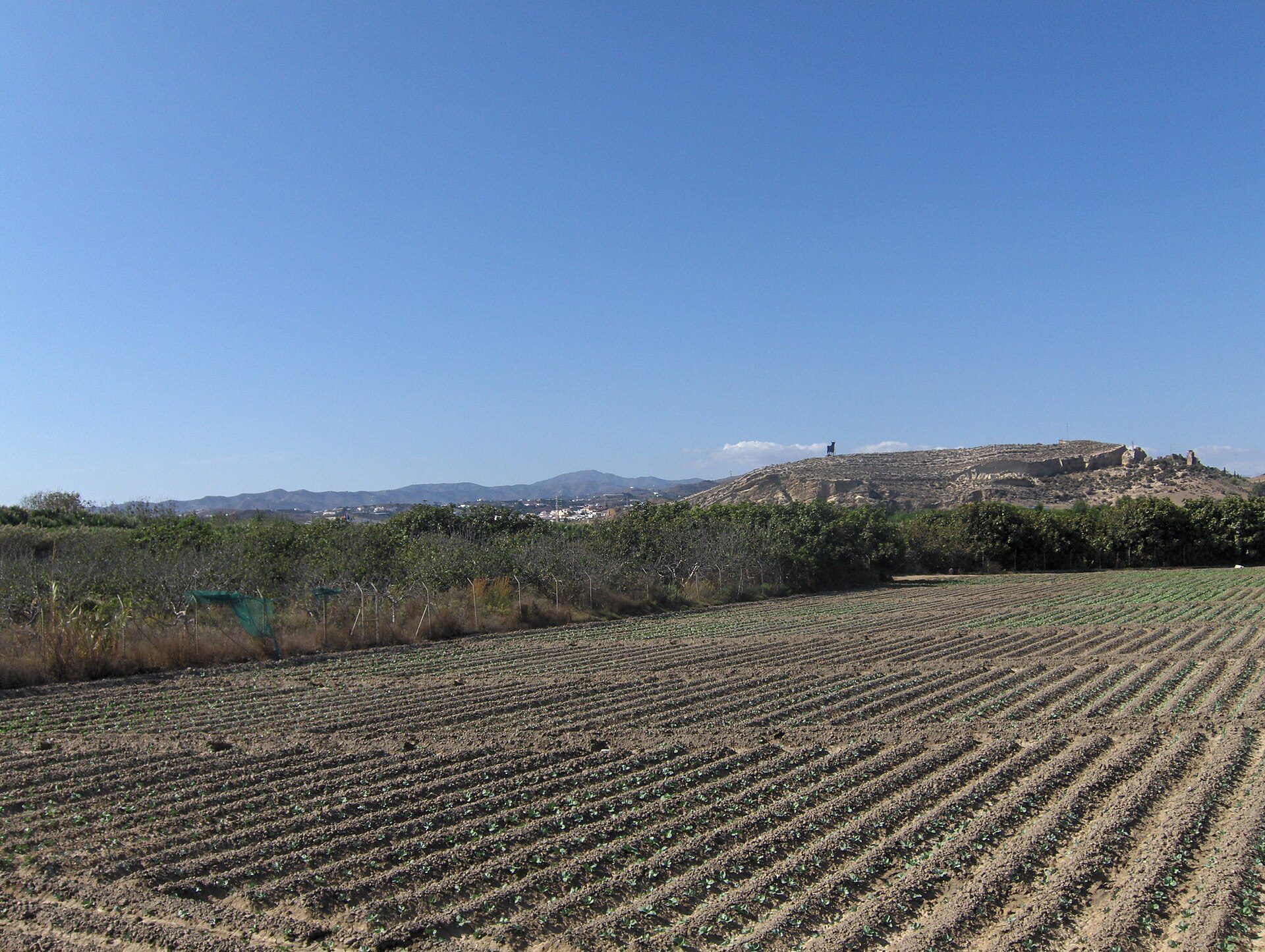 Farmhouse with panoramic view of rolling hills and distant mountains.