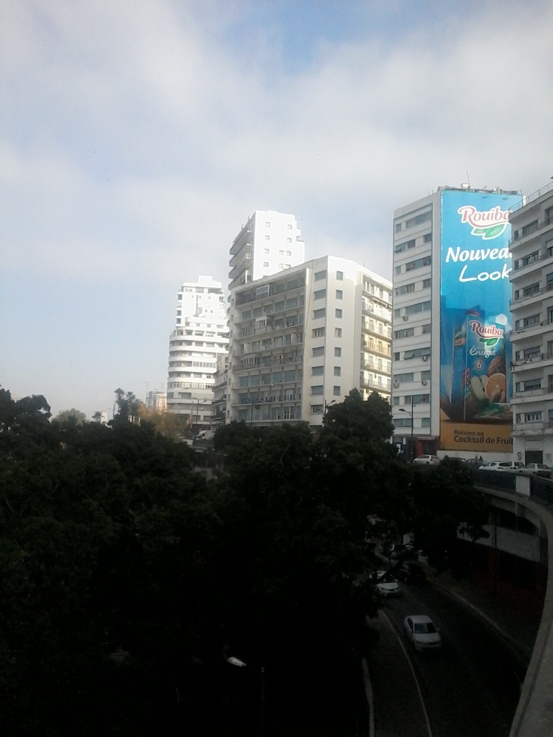 Alt text: Room with city view, large windows, modern furniture, balcony access.