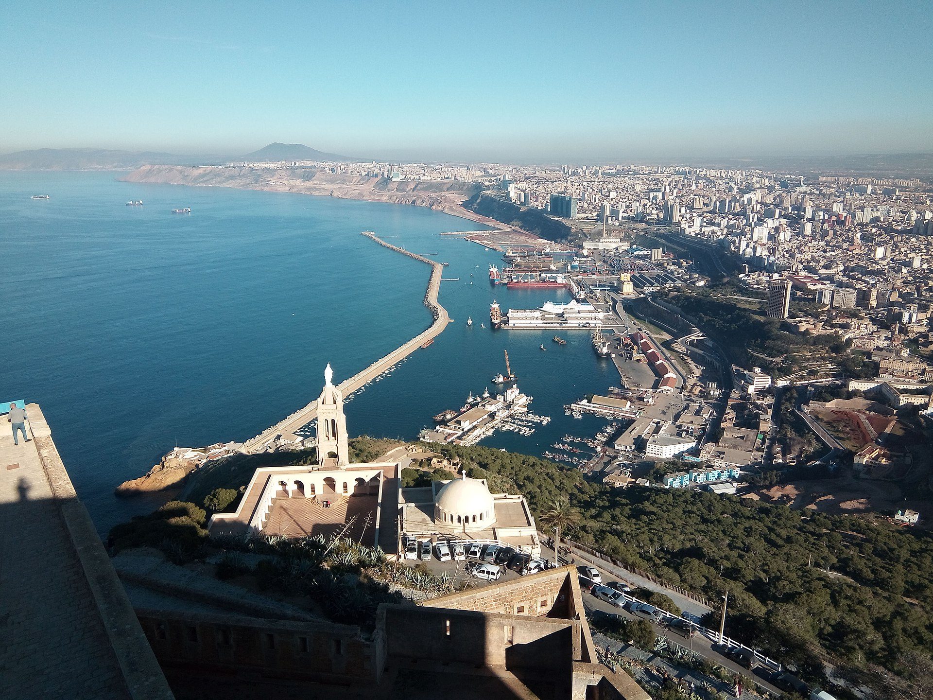 Aerial view of a coastal city with a prominent church and harbor.