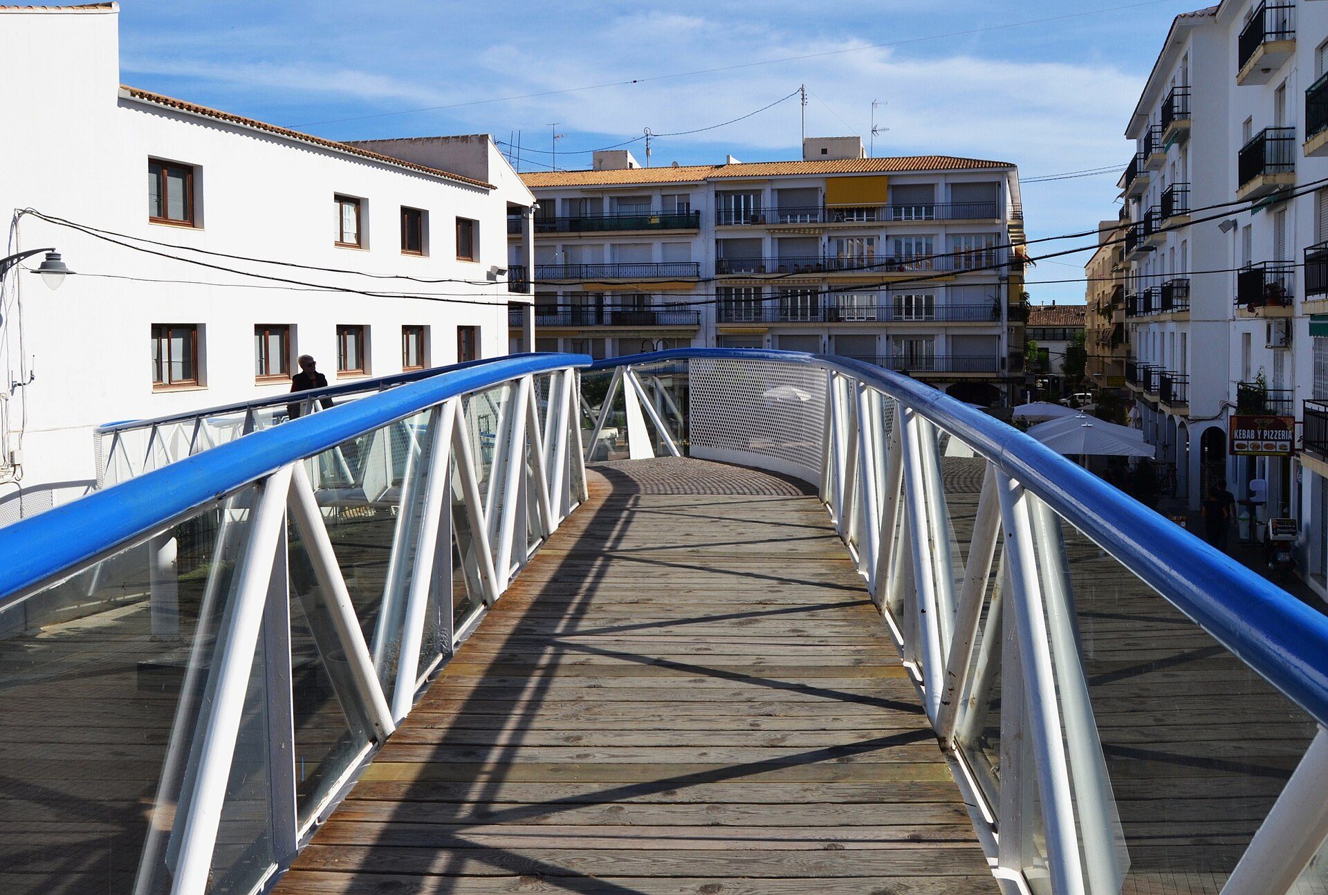 Alt text: Modern apartment with balcony, city view, wooden flooring, and large windows.