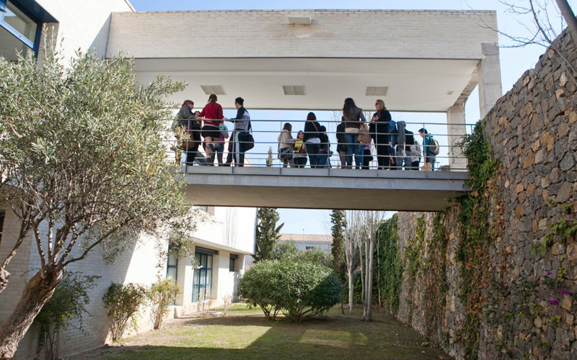 Alt text: Outdoor terrace with a view of a garden and stone wall.