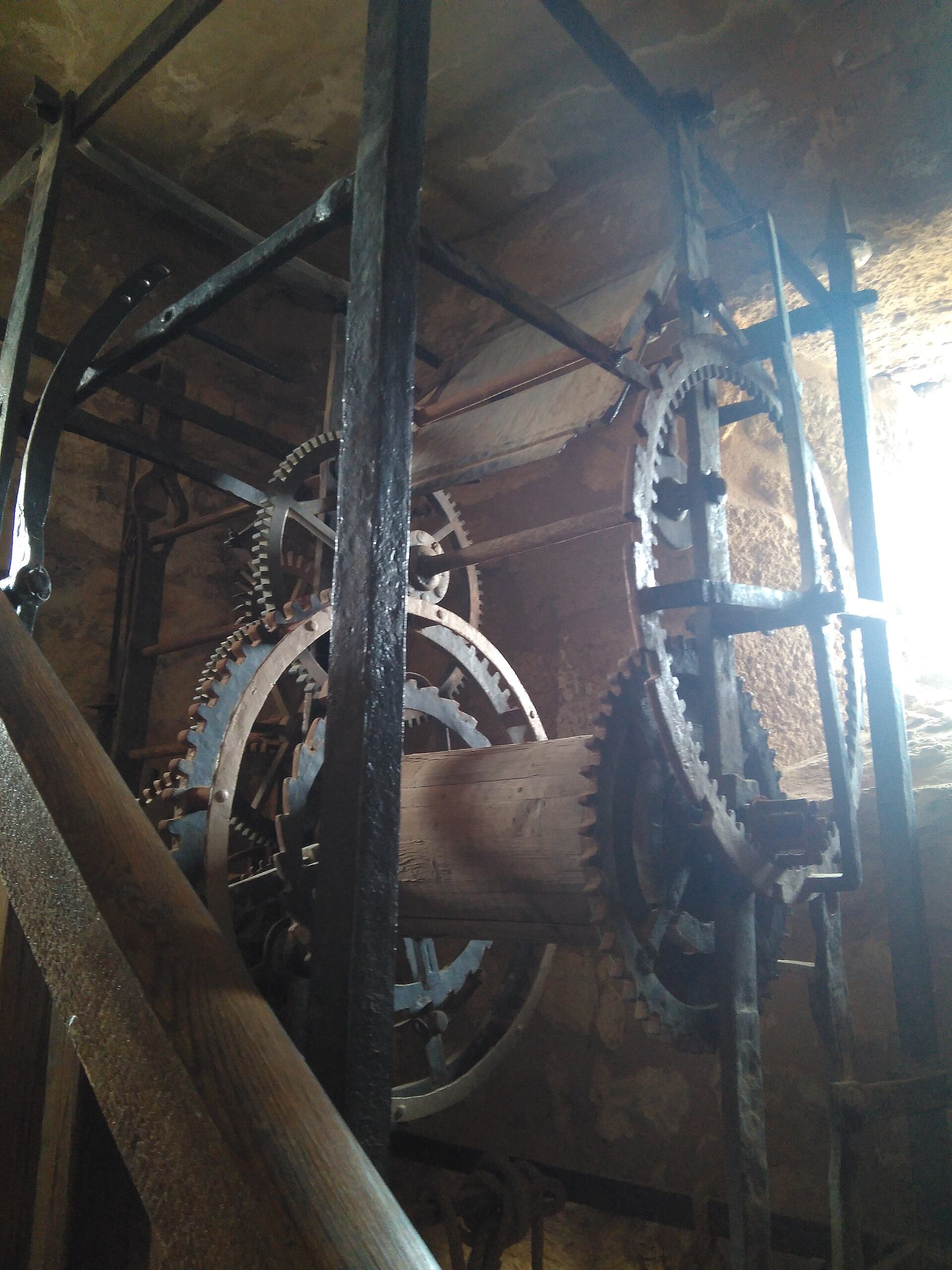 Industrial interior with large gears and metal framework.