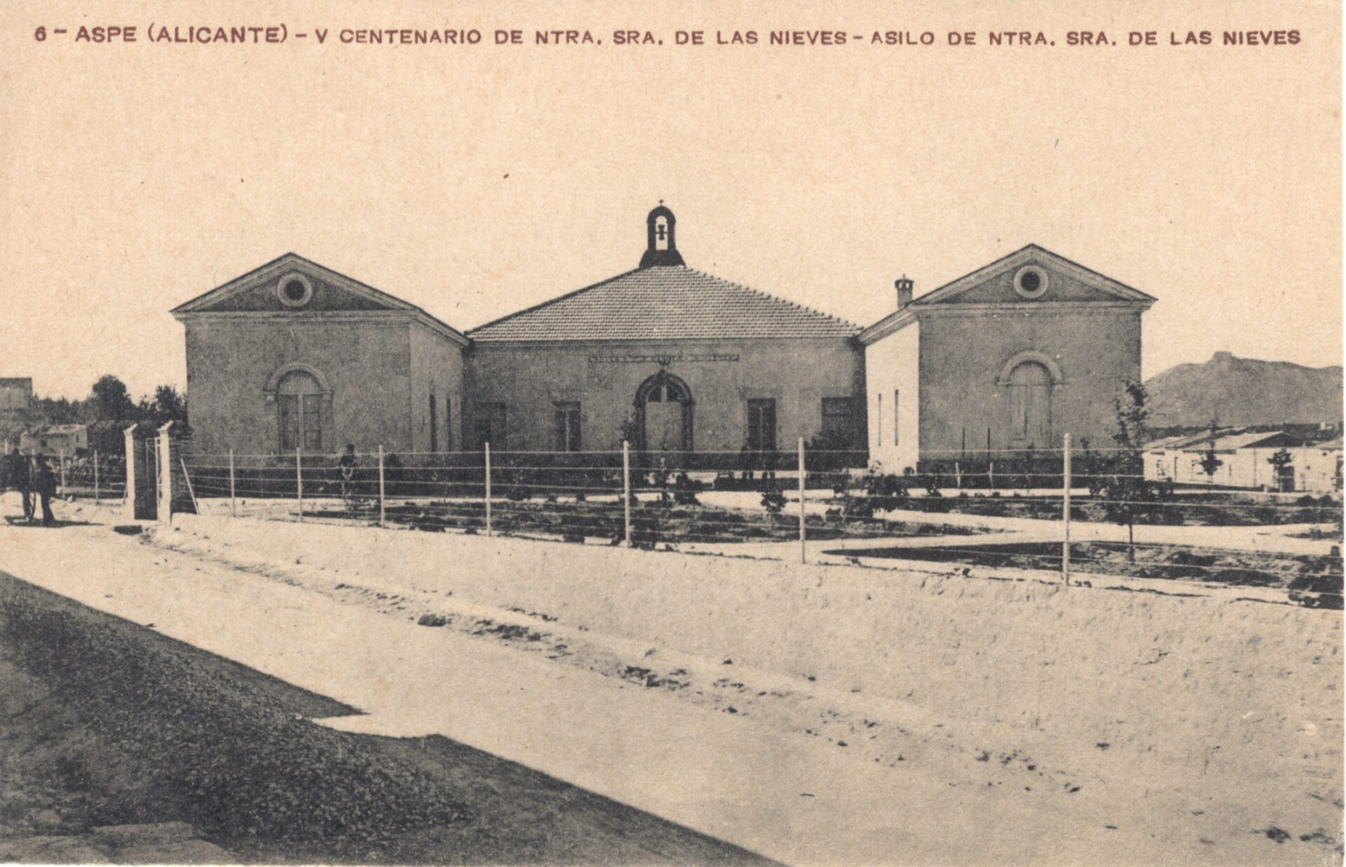 Historic building with a central courtyard, arched windows, and a bell tower.