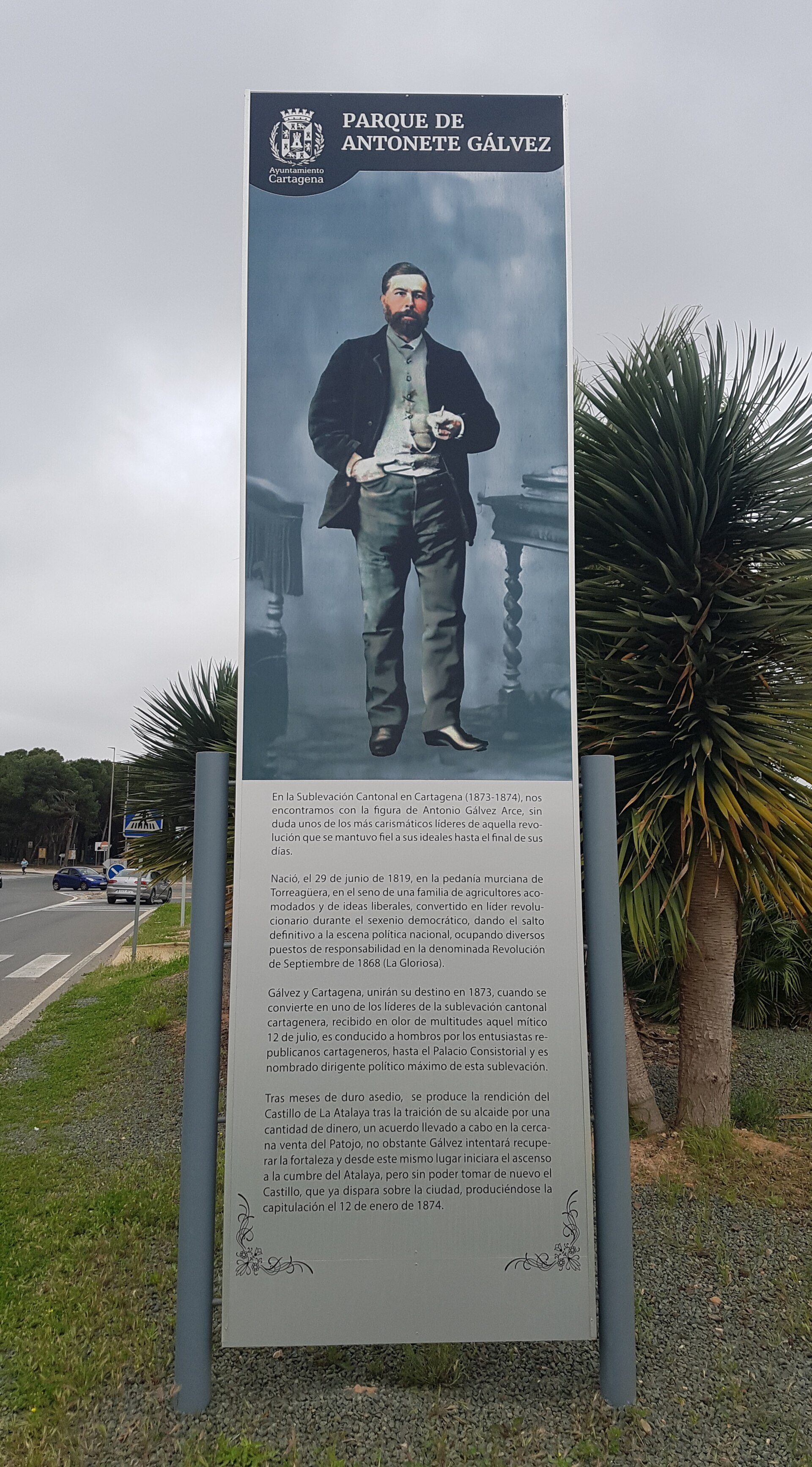 Alt text: Outdoor sign featuring a historical figure with text and a scenic background.