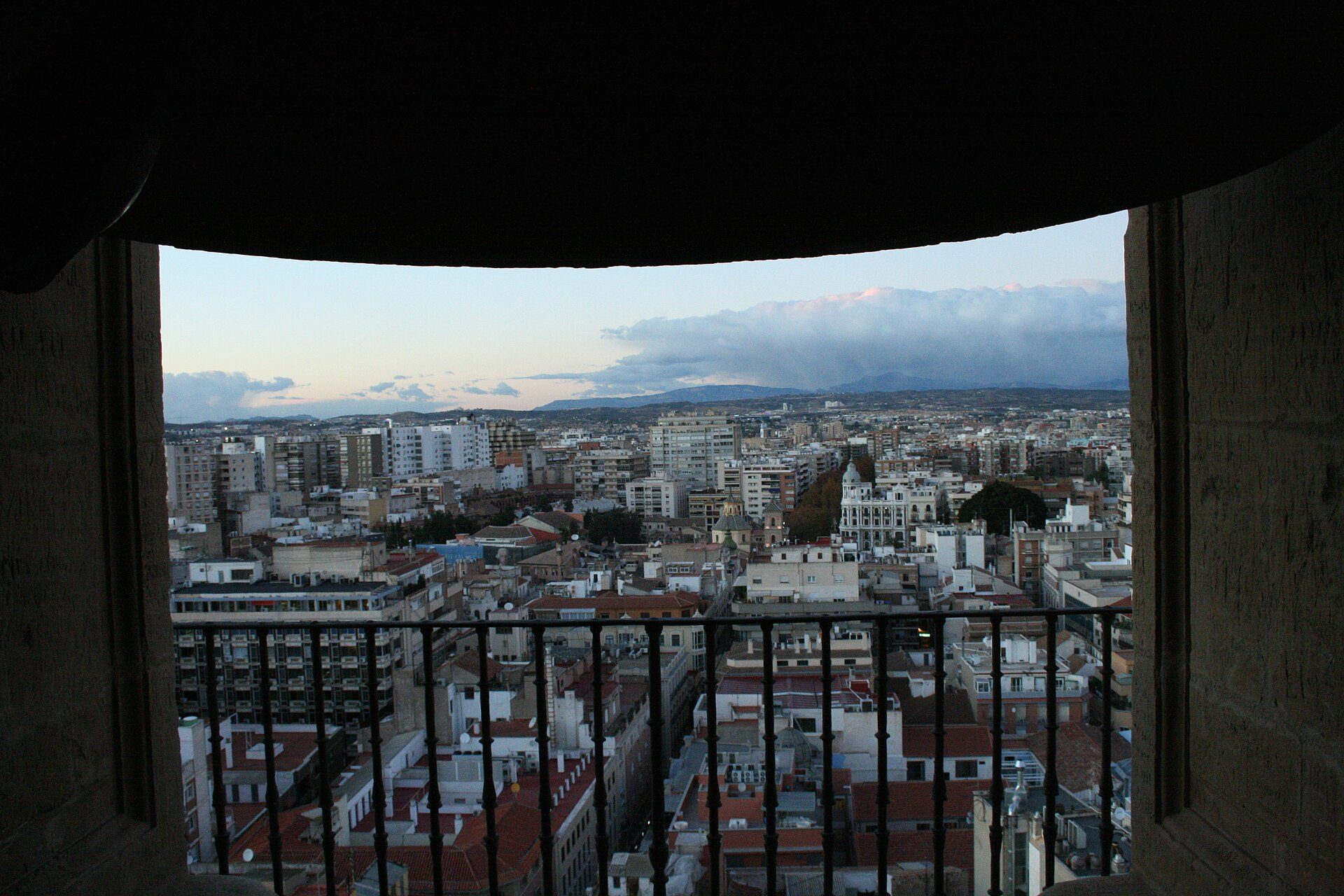 Balcony with city view, featuring a mix of modern and traditional buildings.