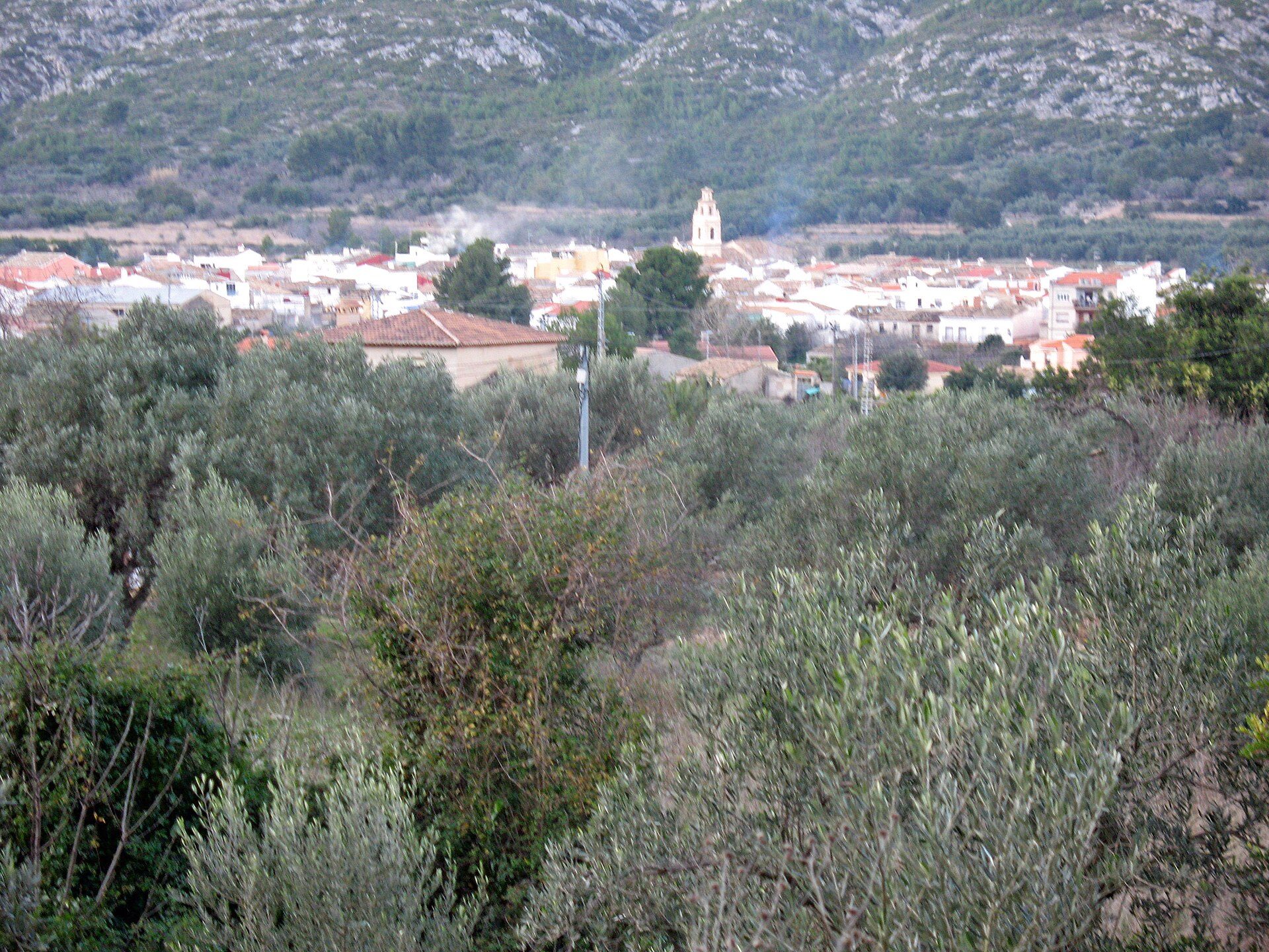 Alt text: Bedroom with scenic town and mountain view, featuring large windows and a balcony.