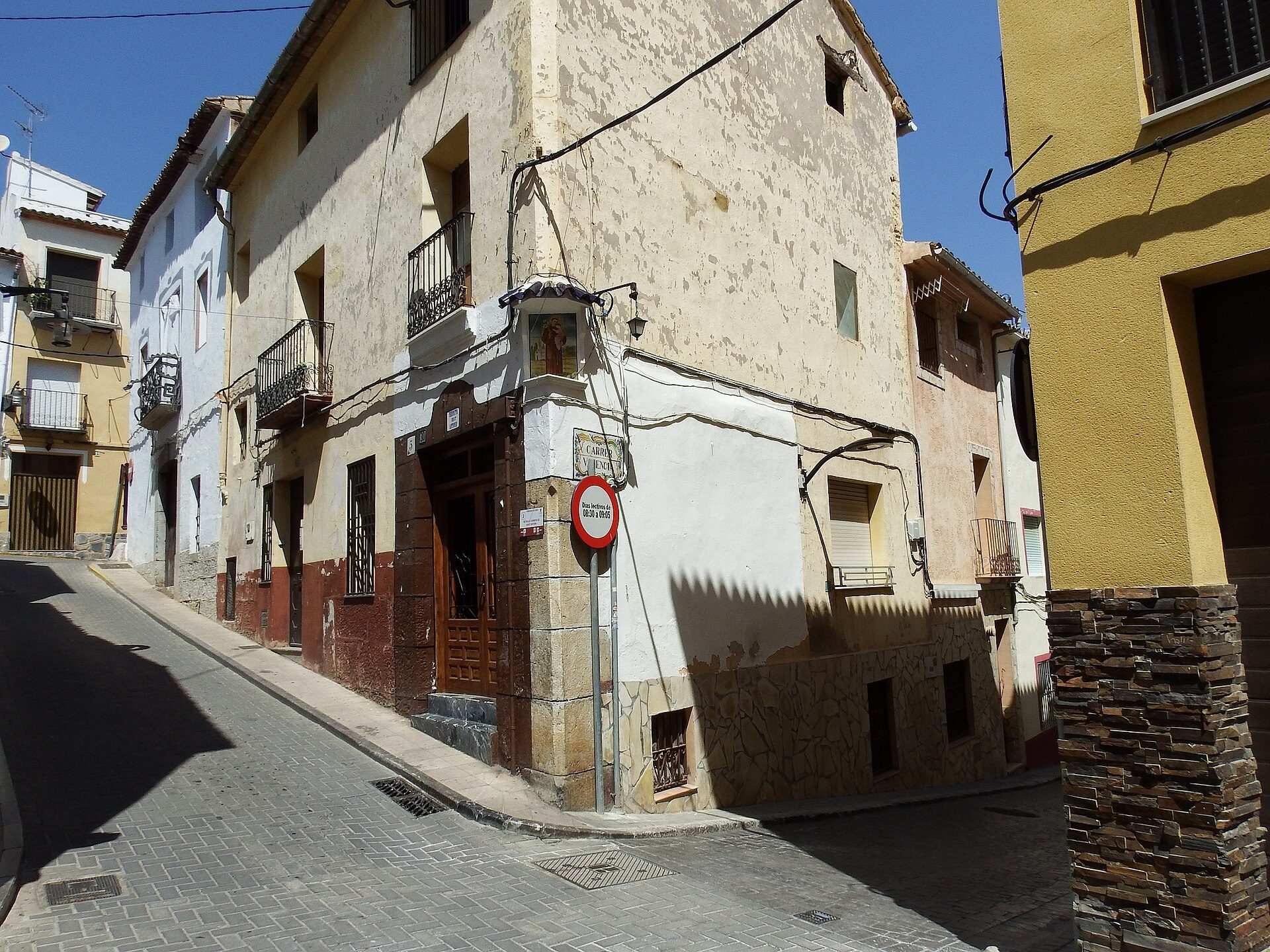 Traditional street view with old buildings, balconies, and a clear blue sky.