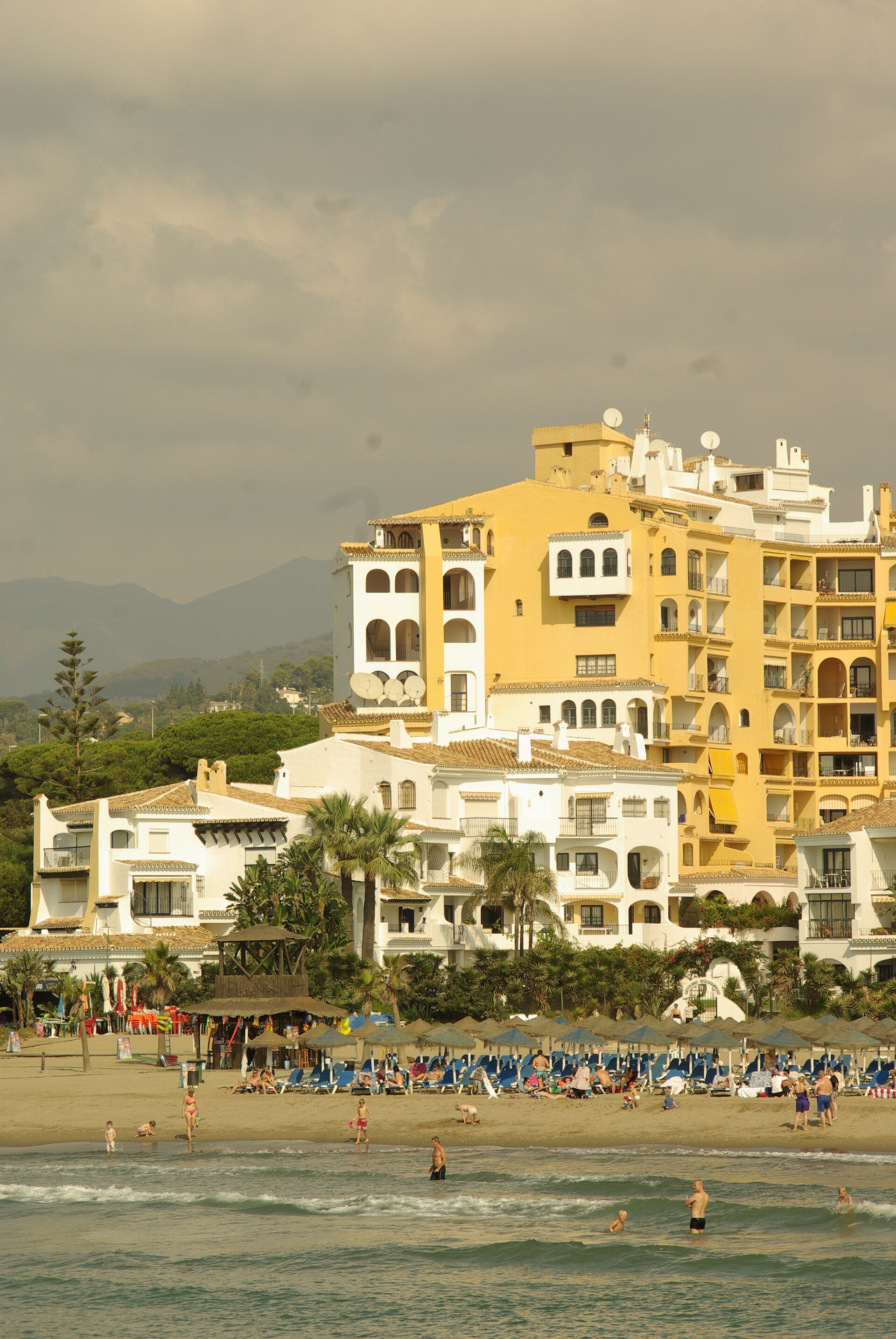 Beachfront hotel with ocean view, spacious rooms, pool, and lounge chairs.