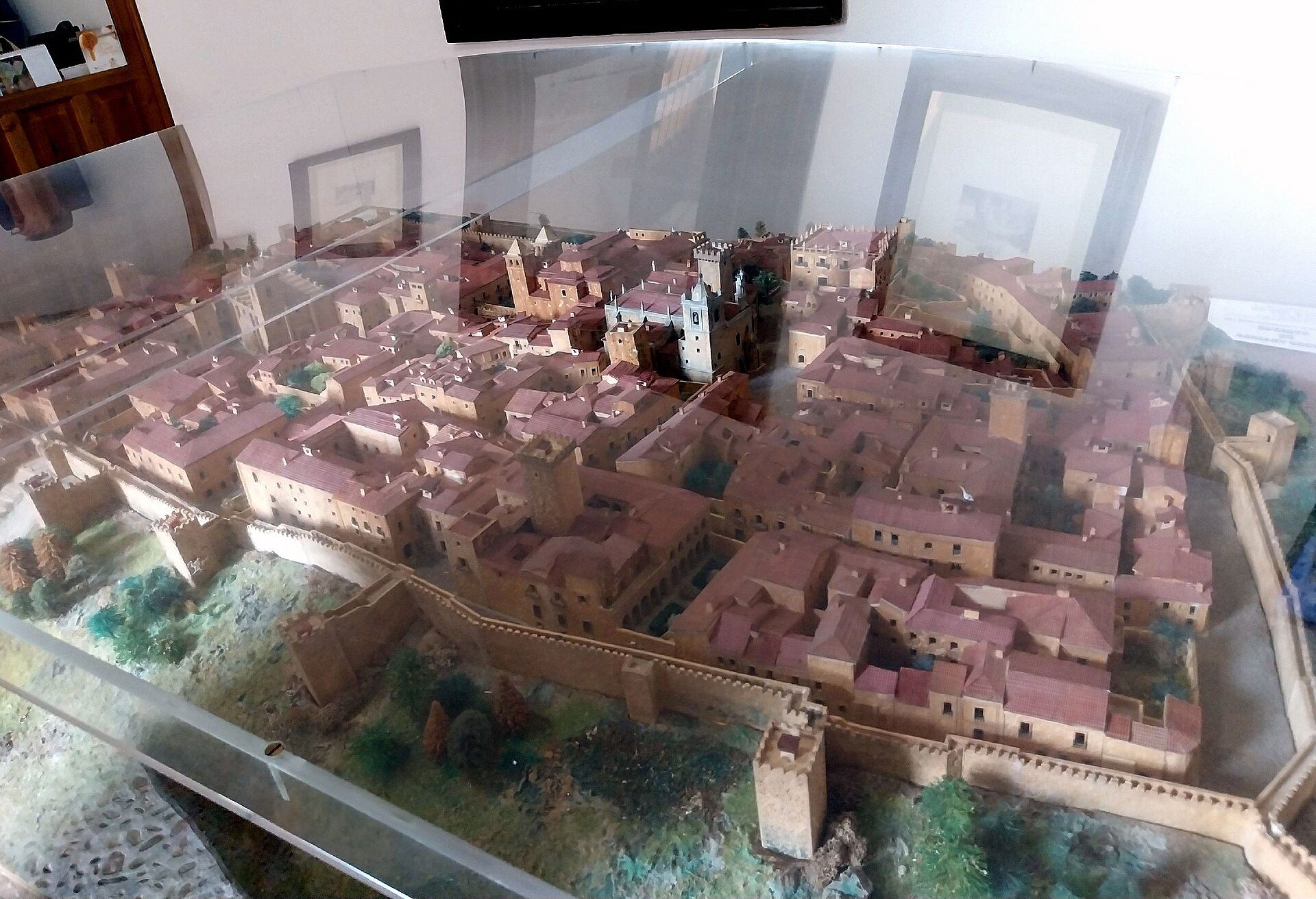 Detailed model of a medieval town with castle and fortified walls.