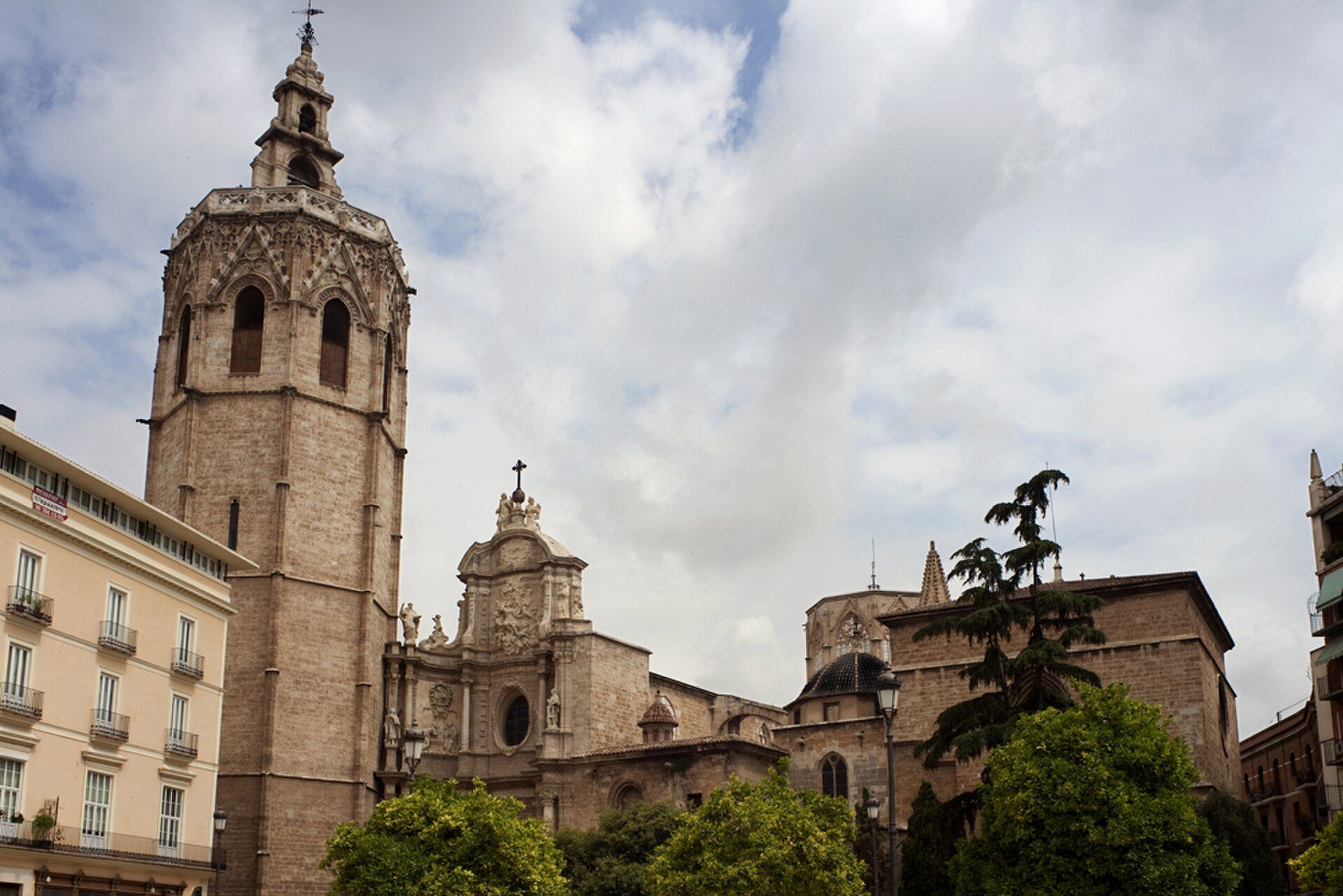 Alt text: Historic church with a tall bell tower and surrounding greenery.