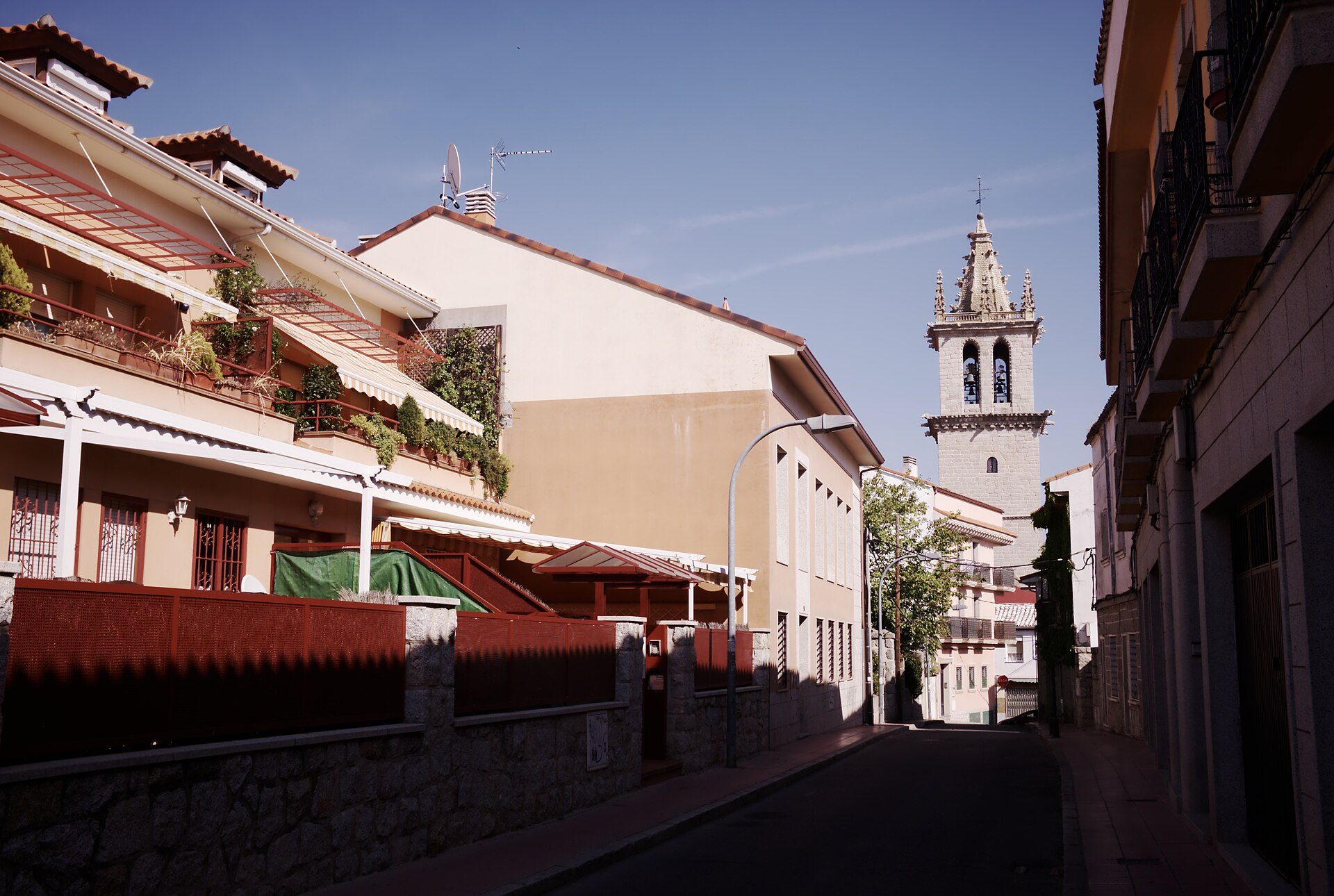 A cozy apartment with a balcony, offering a view of a historic church tower.