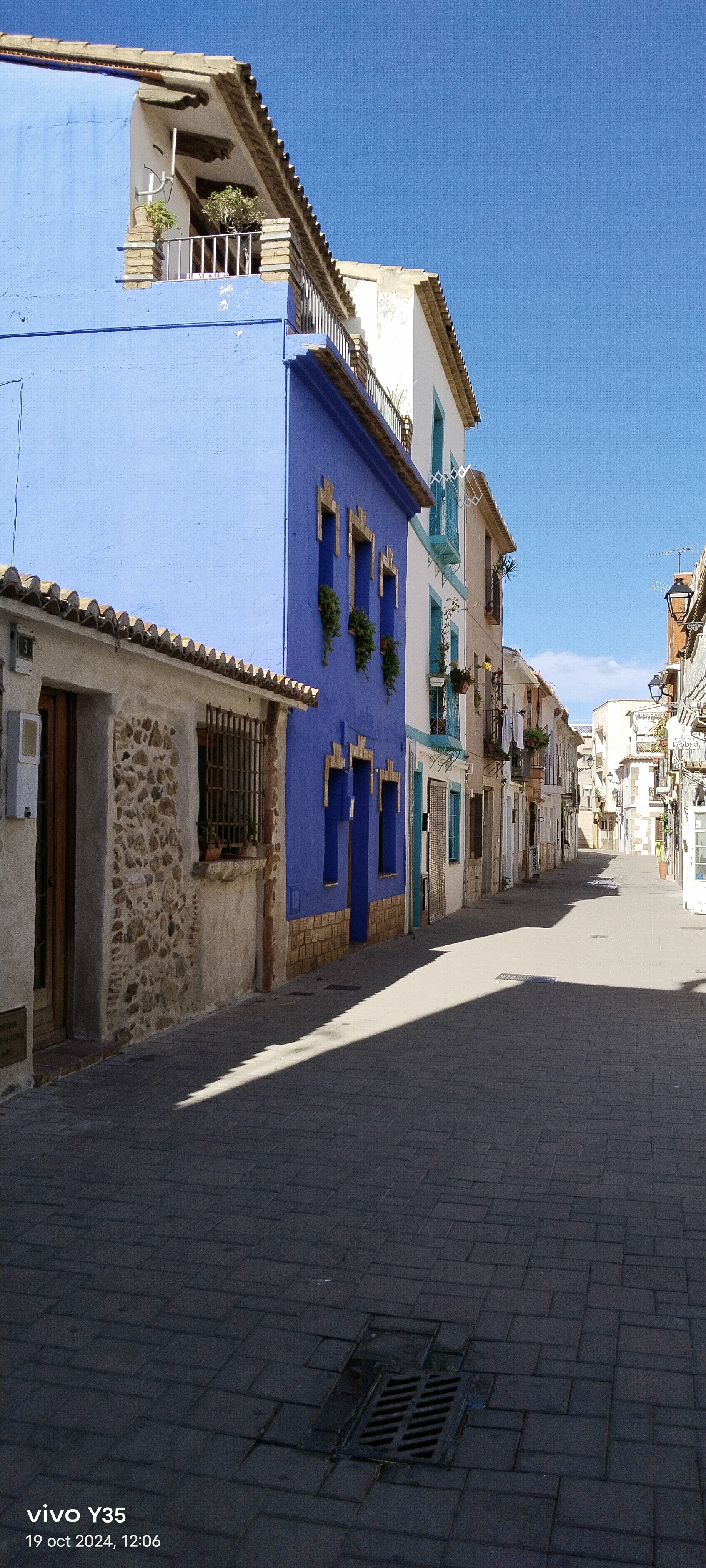 Colorful buildings line a street in Denia, Spain.