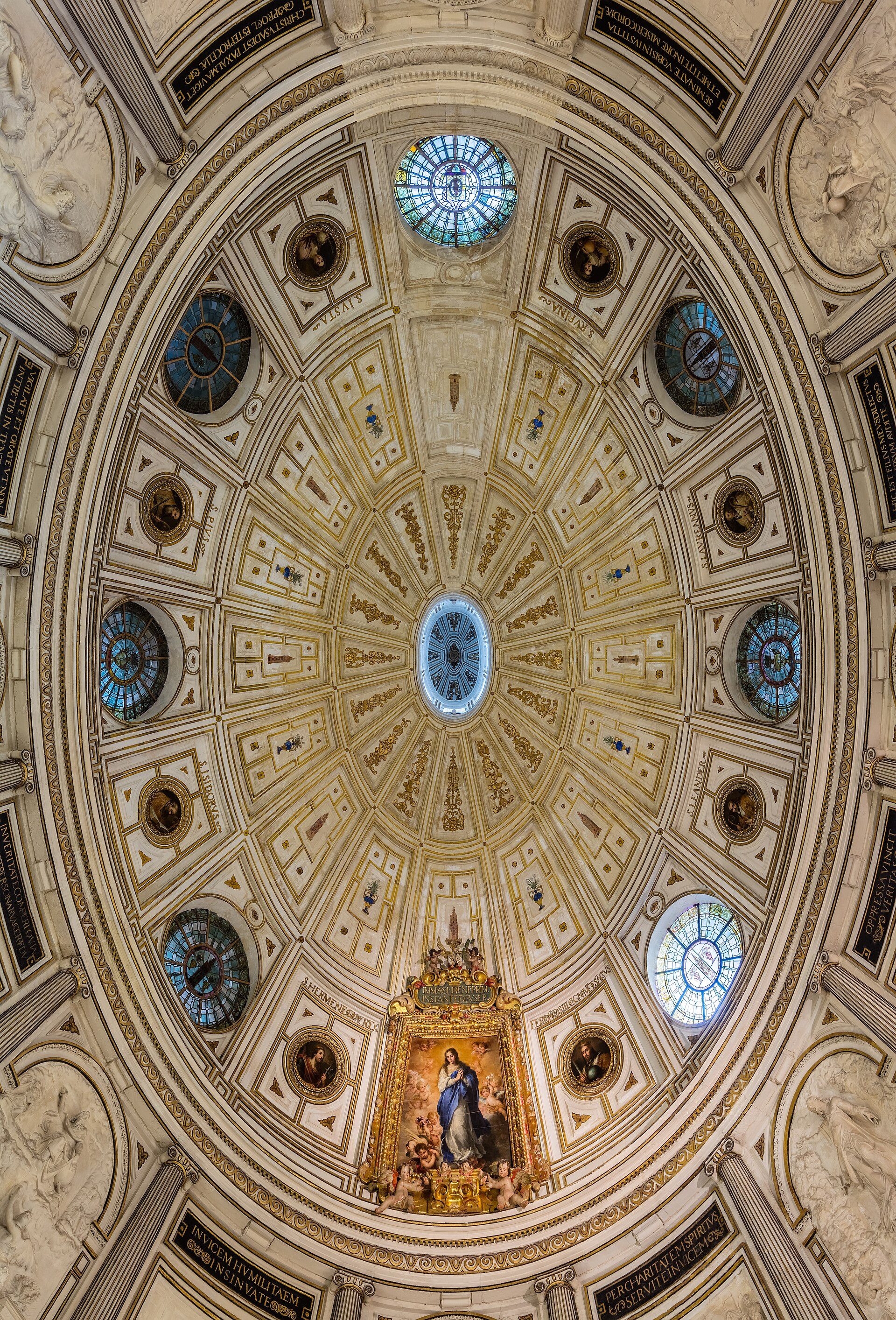 Interior view of a grand dome with intricate frescoes, stained glass windows, and a central religious painting.