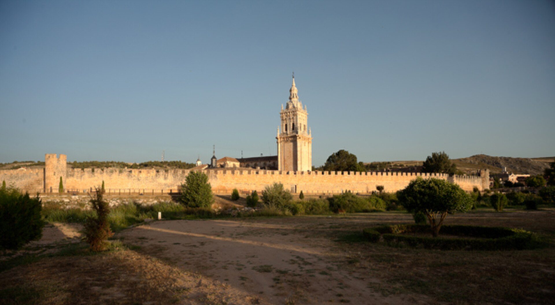 A historic castle with a tall tower and surrounding greenery.