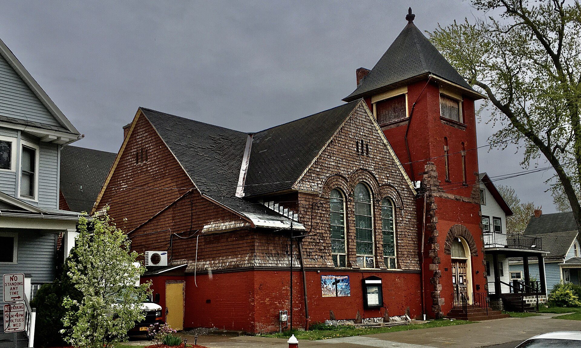 Red brick church with arched windows, gabled roof, and a small tower.