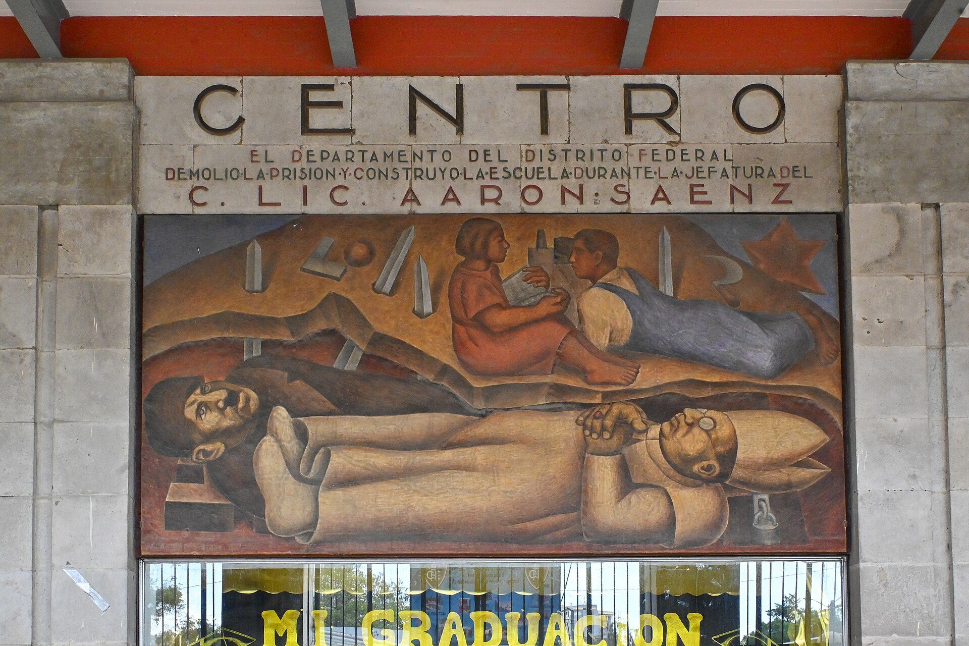 Mural depicting workers and a star, above a sign reading "CENTRO" and "GRADUACIÓN" in a building.