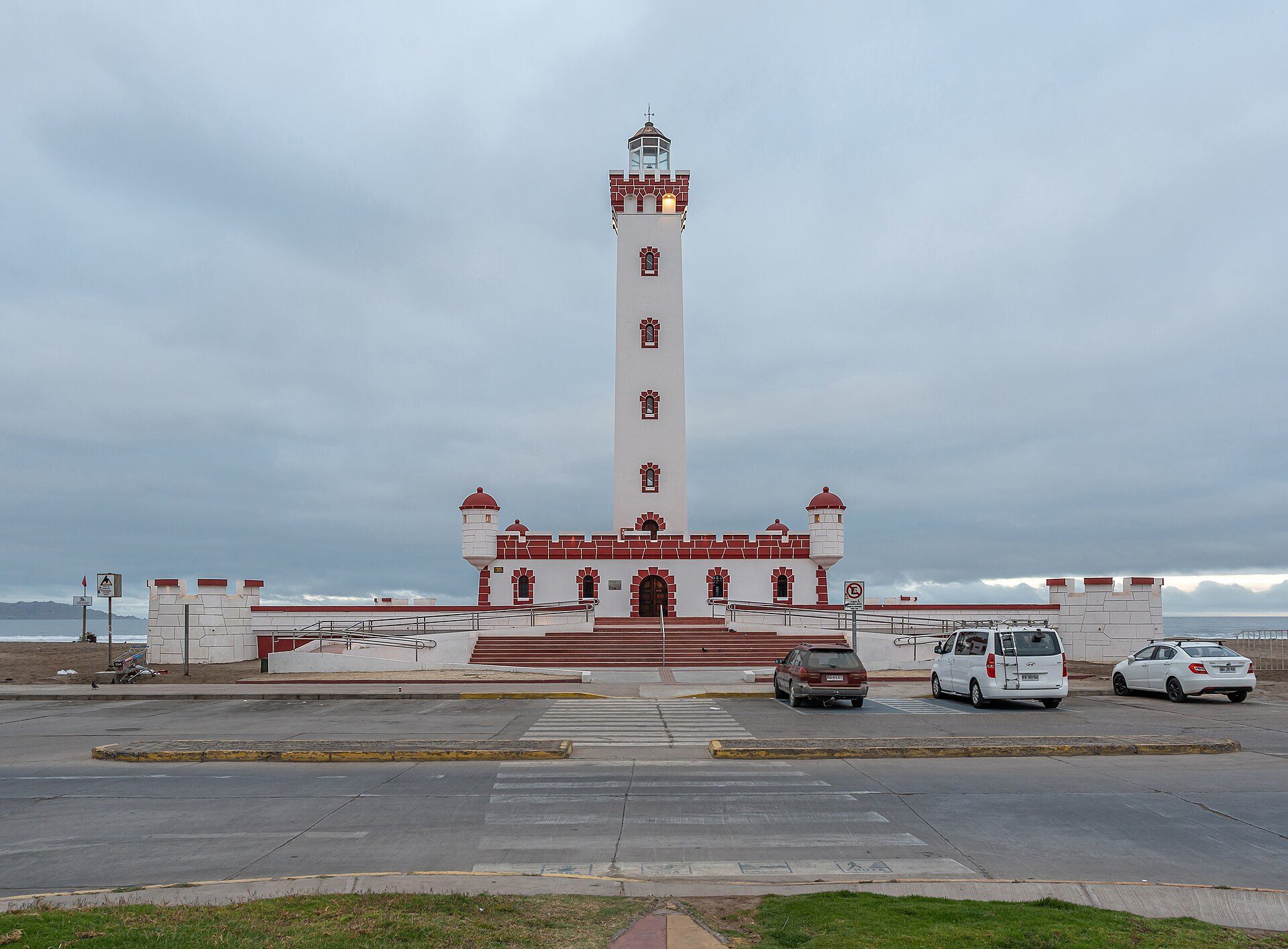 Alt text: White lighthouse with red accents, ocean view, parking available.