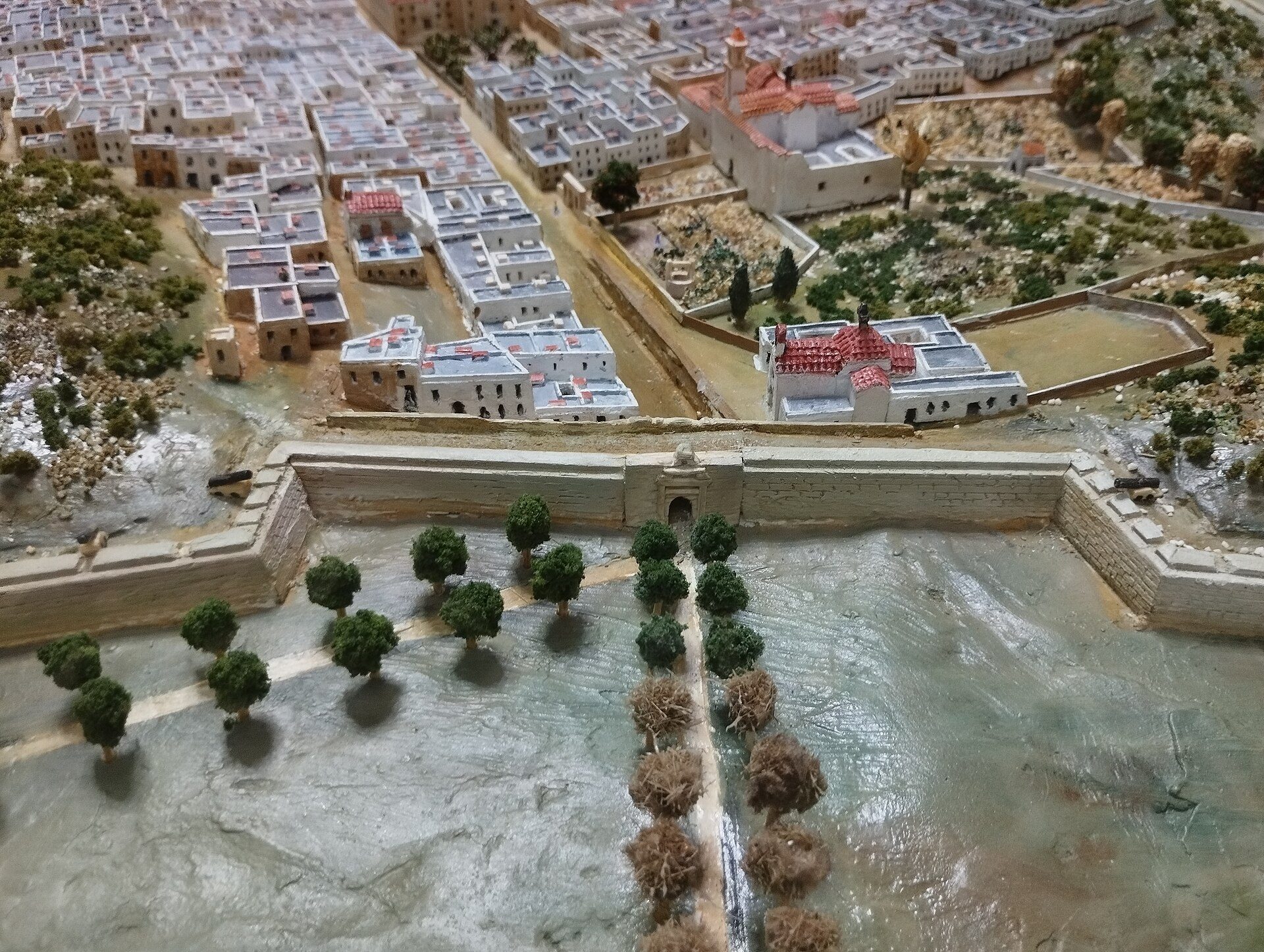 Alt text: Detailed model of a Mediterranean town with white buildings, red roofs, and a central waterway.