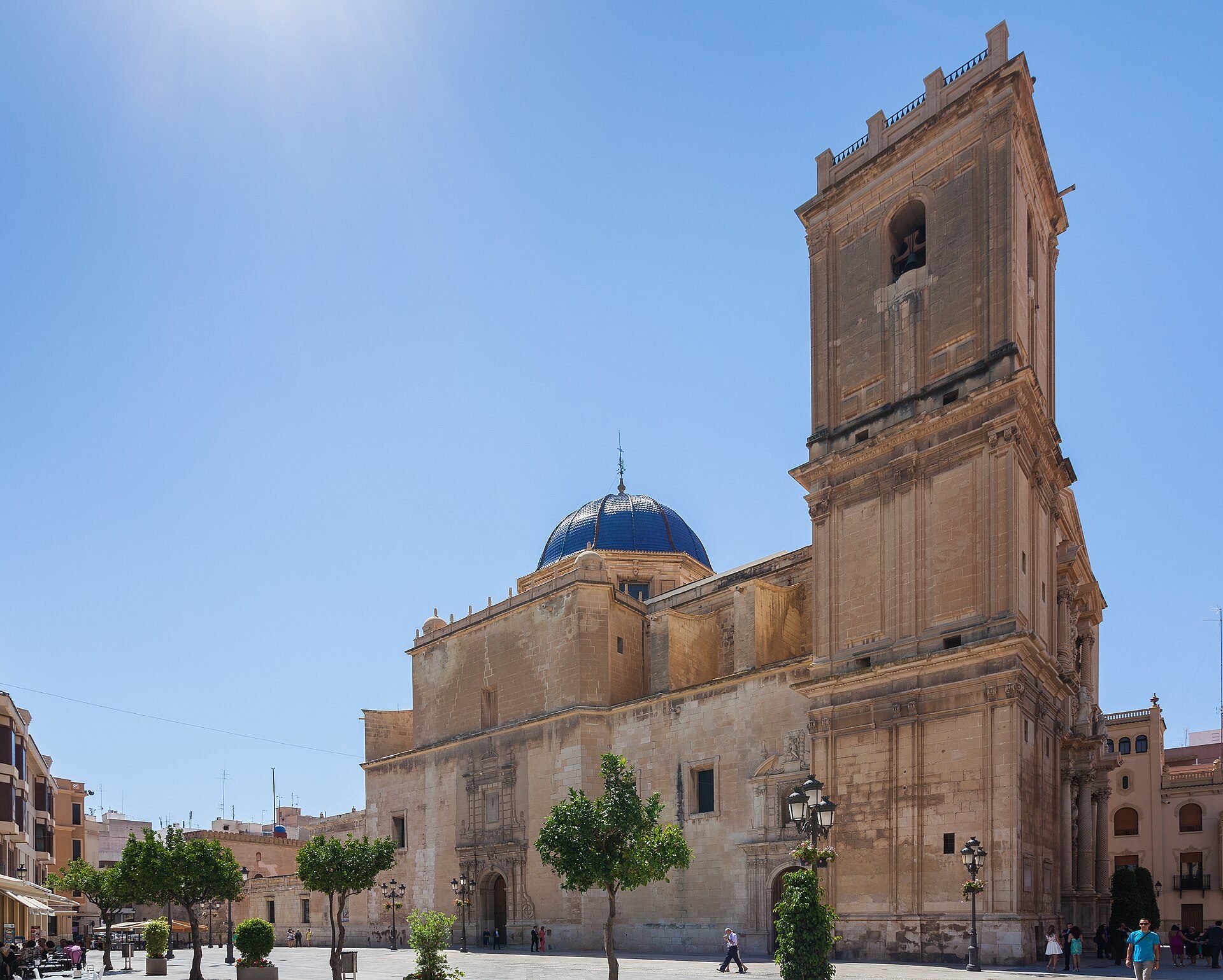 Alt text: Historic church with blue dome and bell tower, surrounded by trees and a clear blue sky.