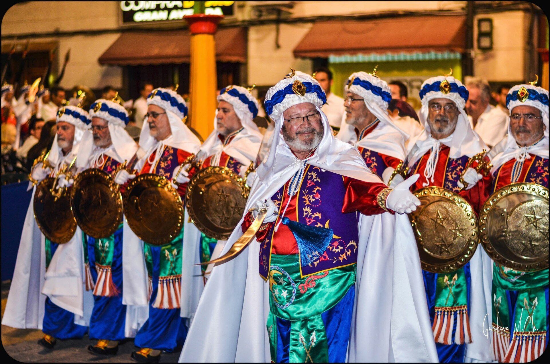 Traditional band in colorful costumes playing drums and cymbals.