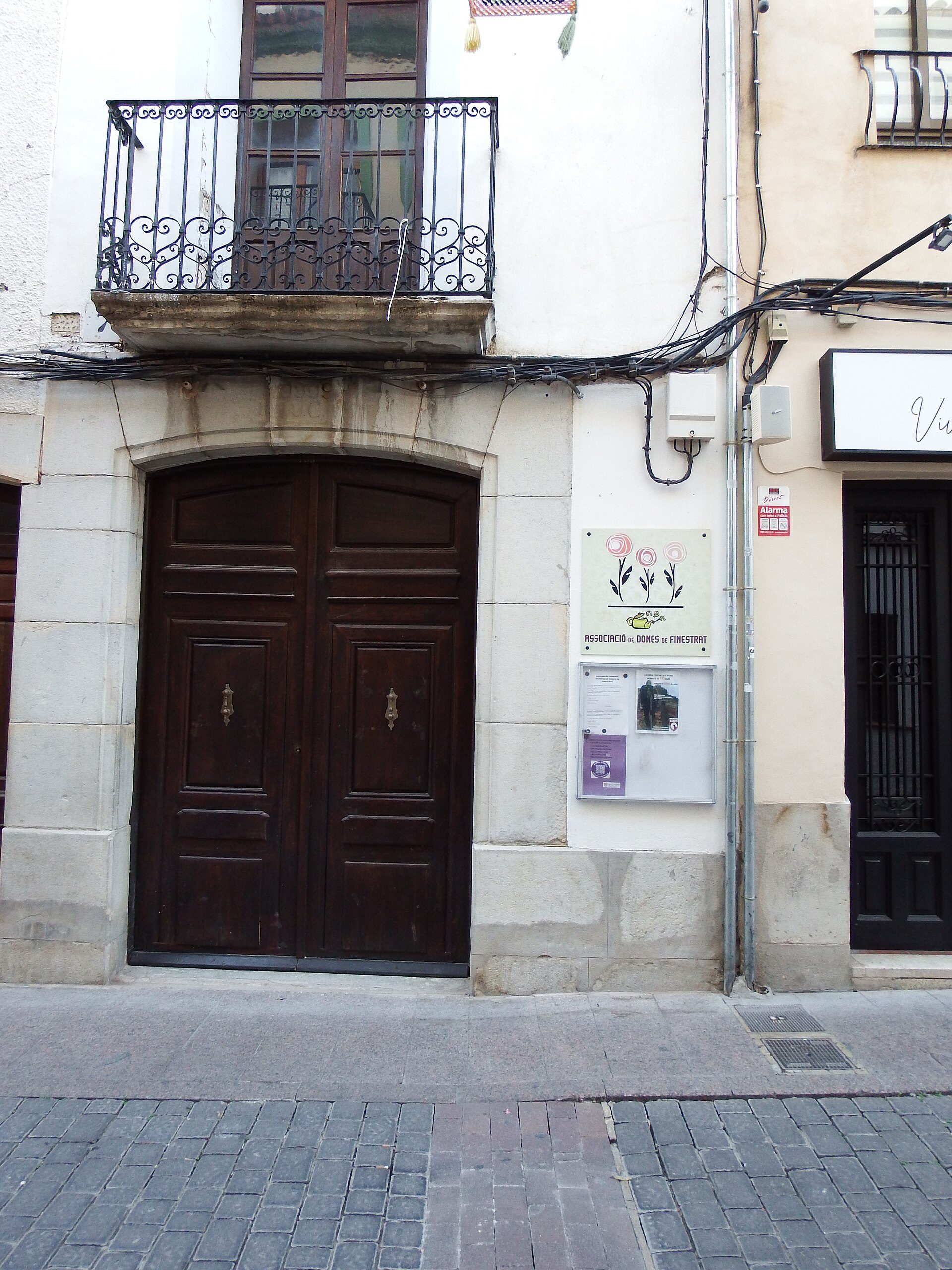 Traditional apartment with balcony, wooden doors, and stone facade.