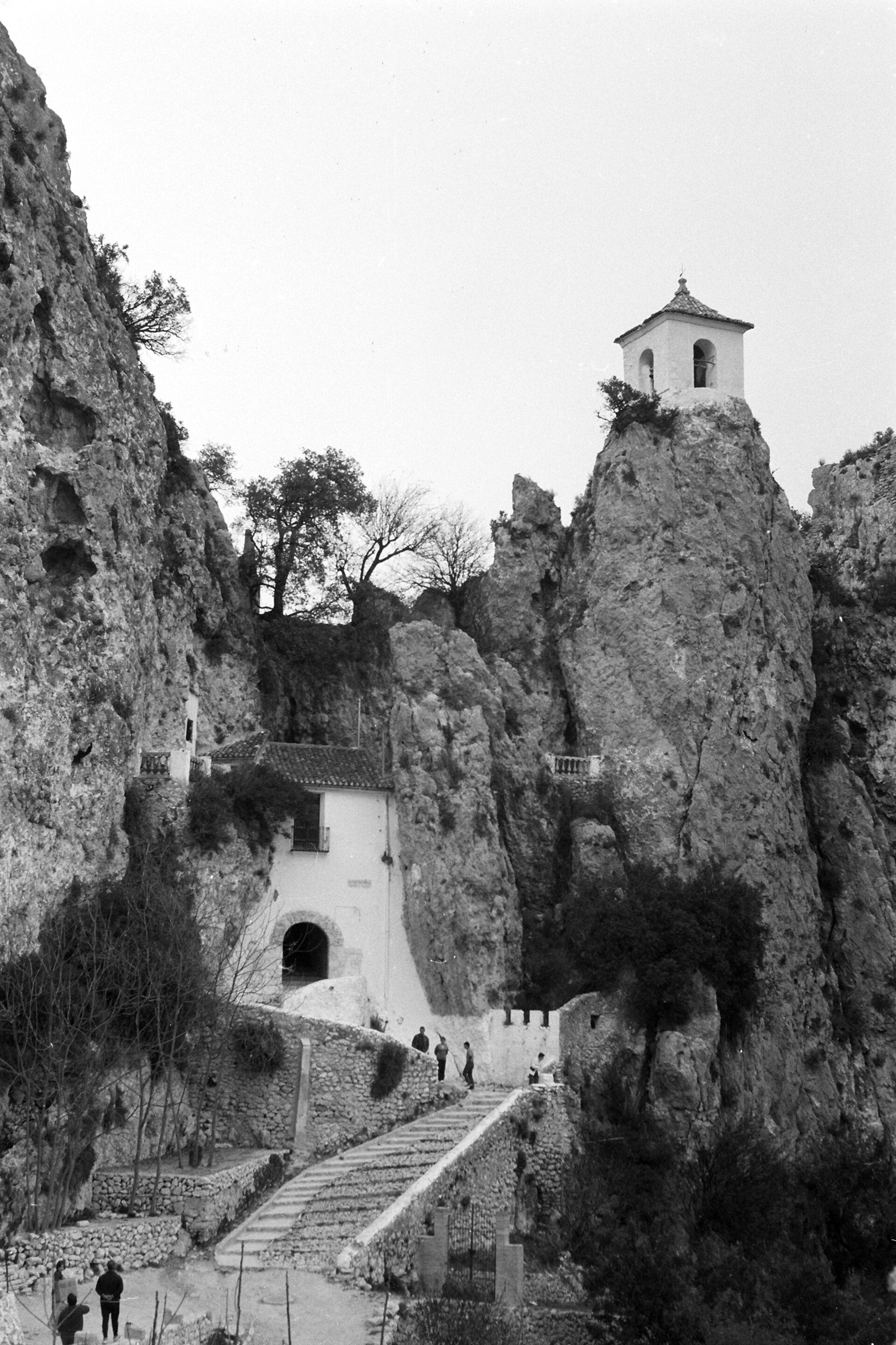 Alt text: Stone staircase leading to a small temple with mountainous backdrop.