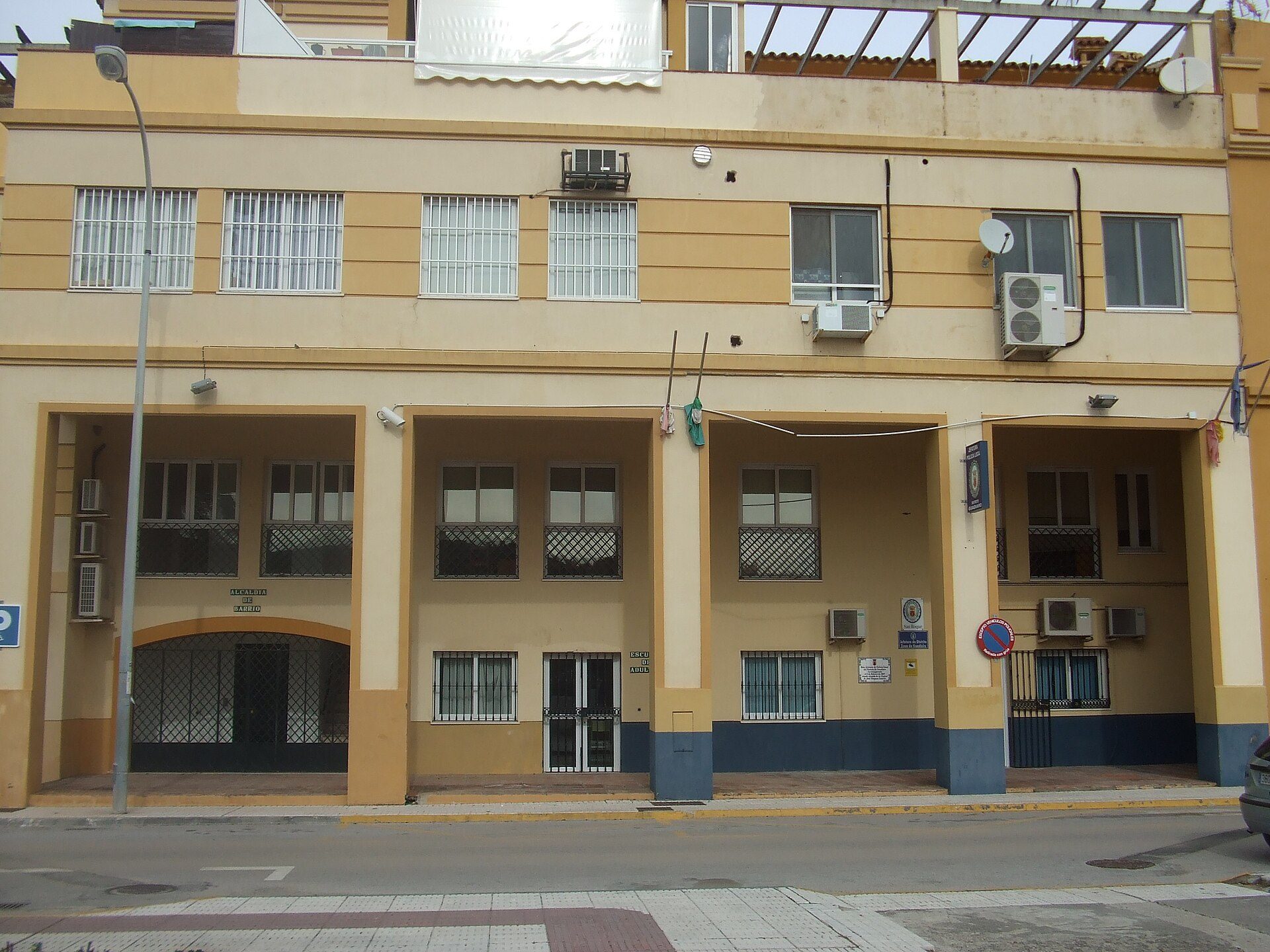 A three-story building with balconies, air conditioning, and street view.