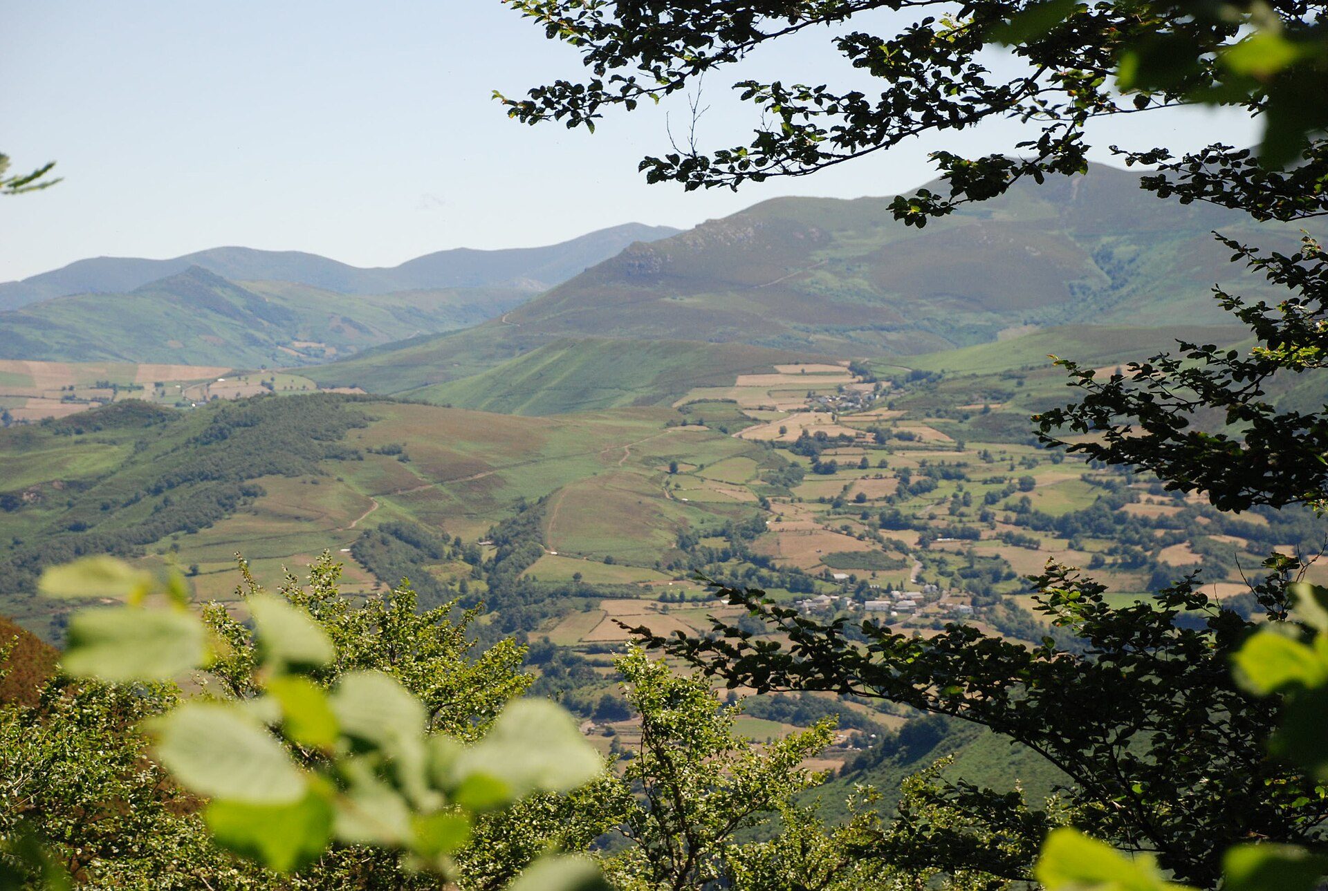 Alt text: Panoramic view of lush green hills and valleys from a cozy room.
