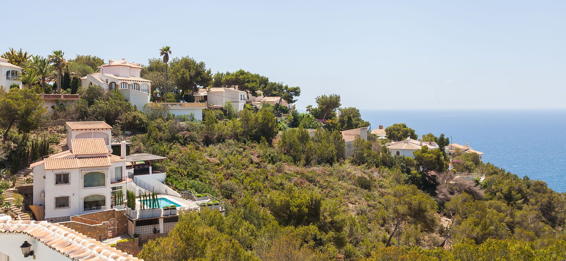 Luxurious villa with private pool, ocean view, and terraced gardens.