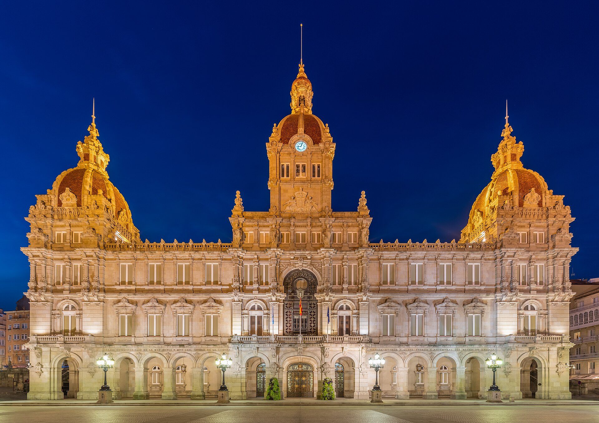 Alt text: Historic building with domes, clock tower, and ornate architecture at night.