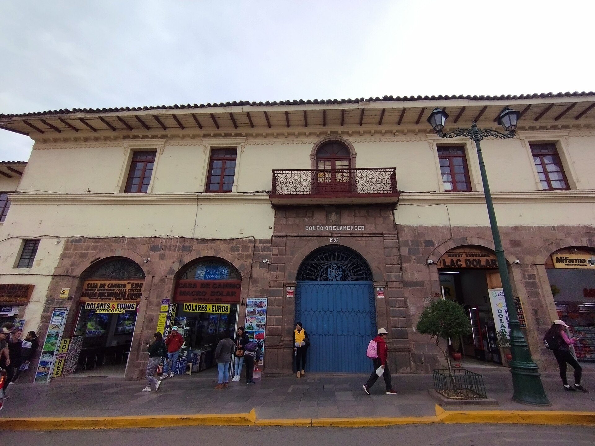 Traditional building with arched entrances, balconies, and a blue door.