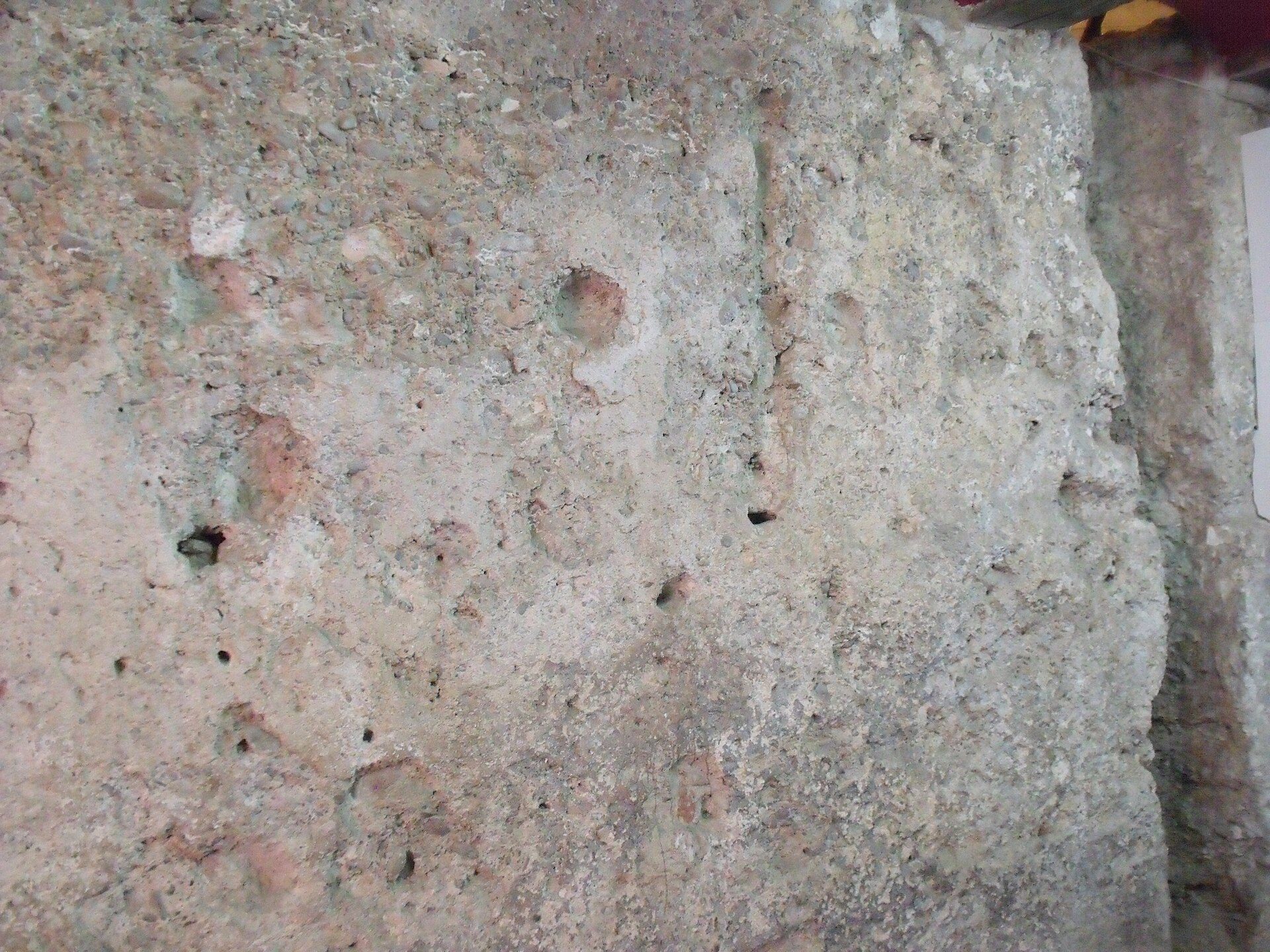 Close-up of a textured stone wall with small holes and a rough surface.