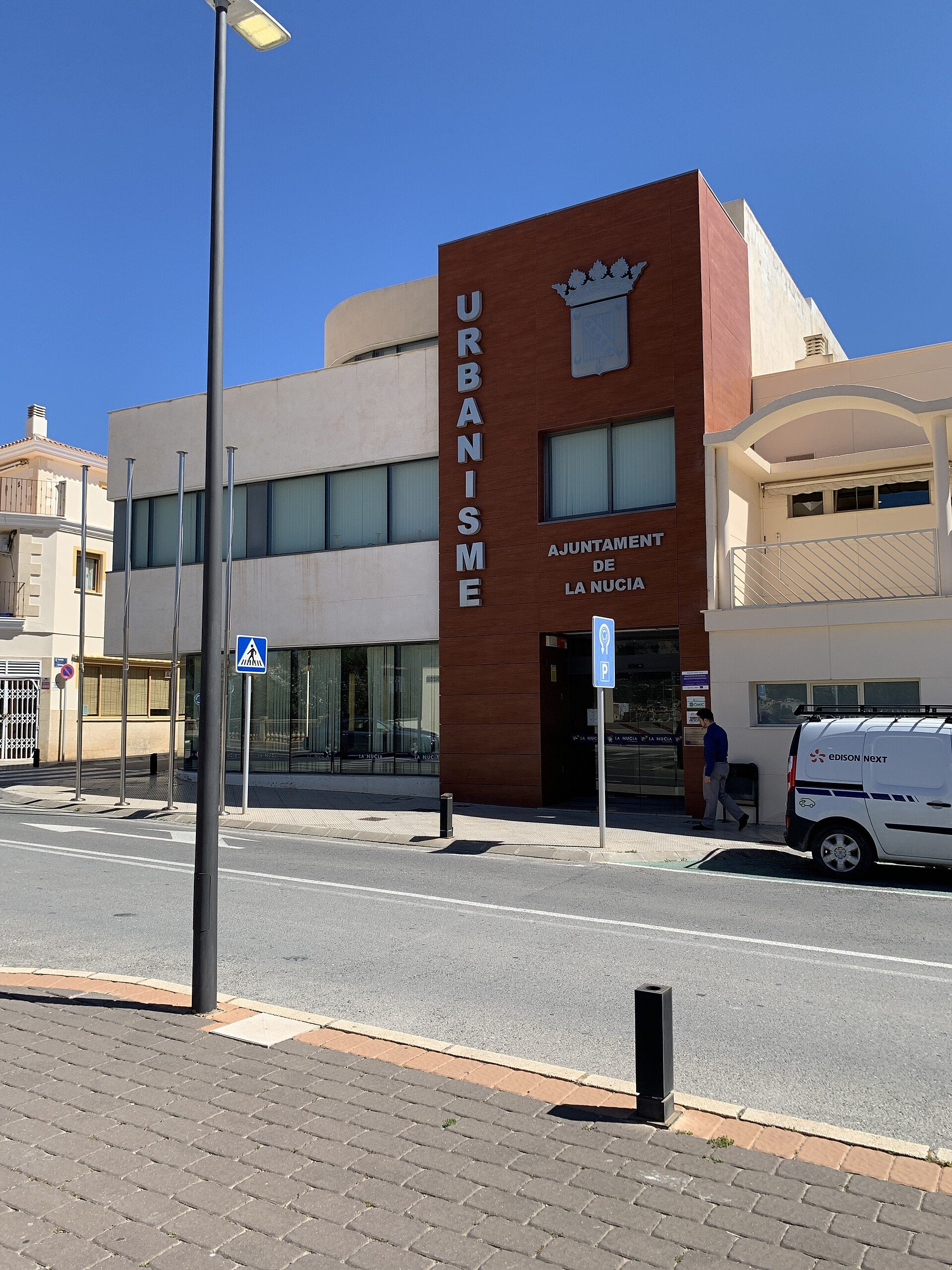 Modern building with large windows, urban setting, street view.