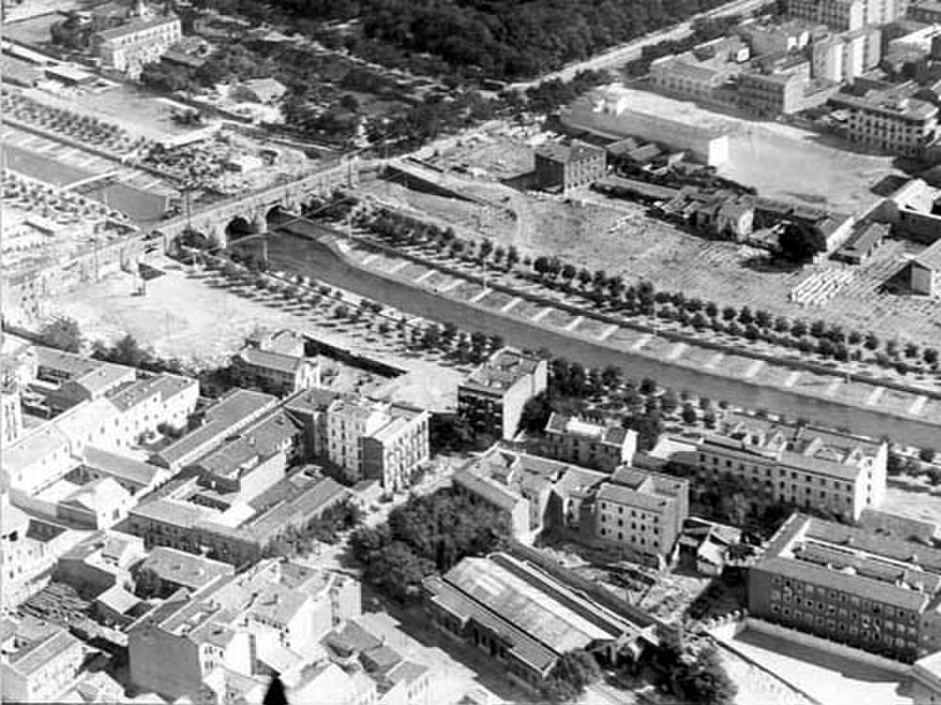Aerial view of a cityscape with buildings, streets, and greenery.