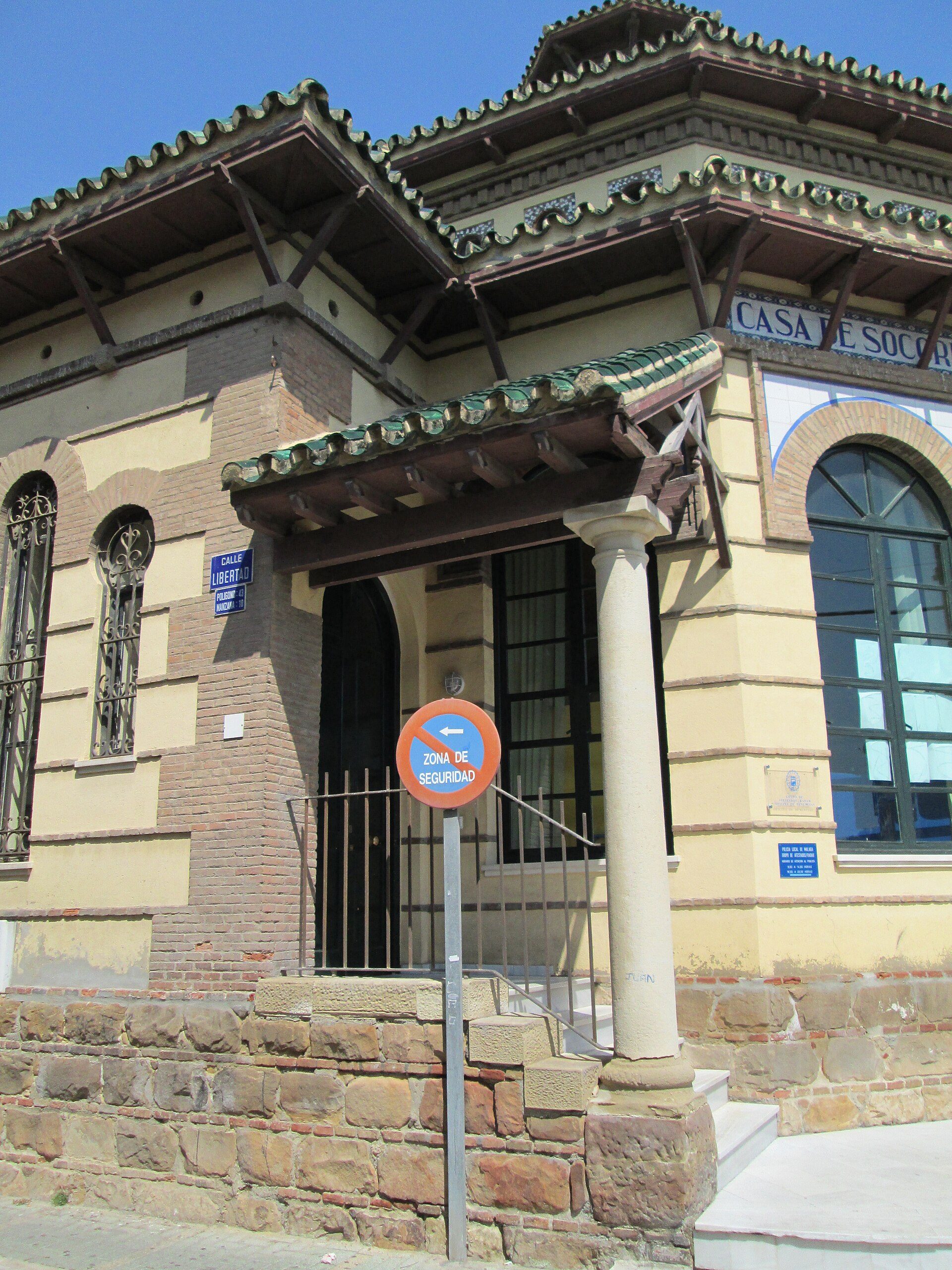 Traditional building with arched windows, stone base, and decorative roof.