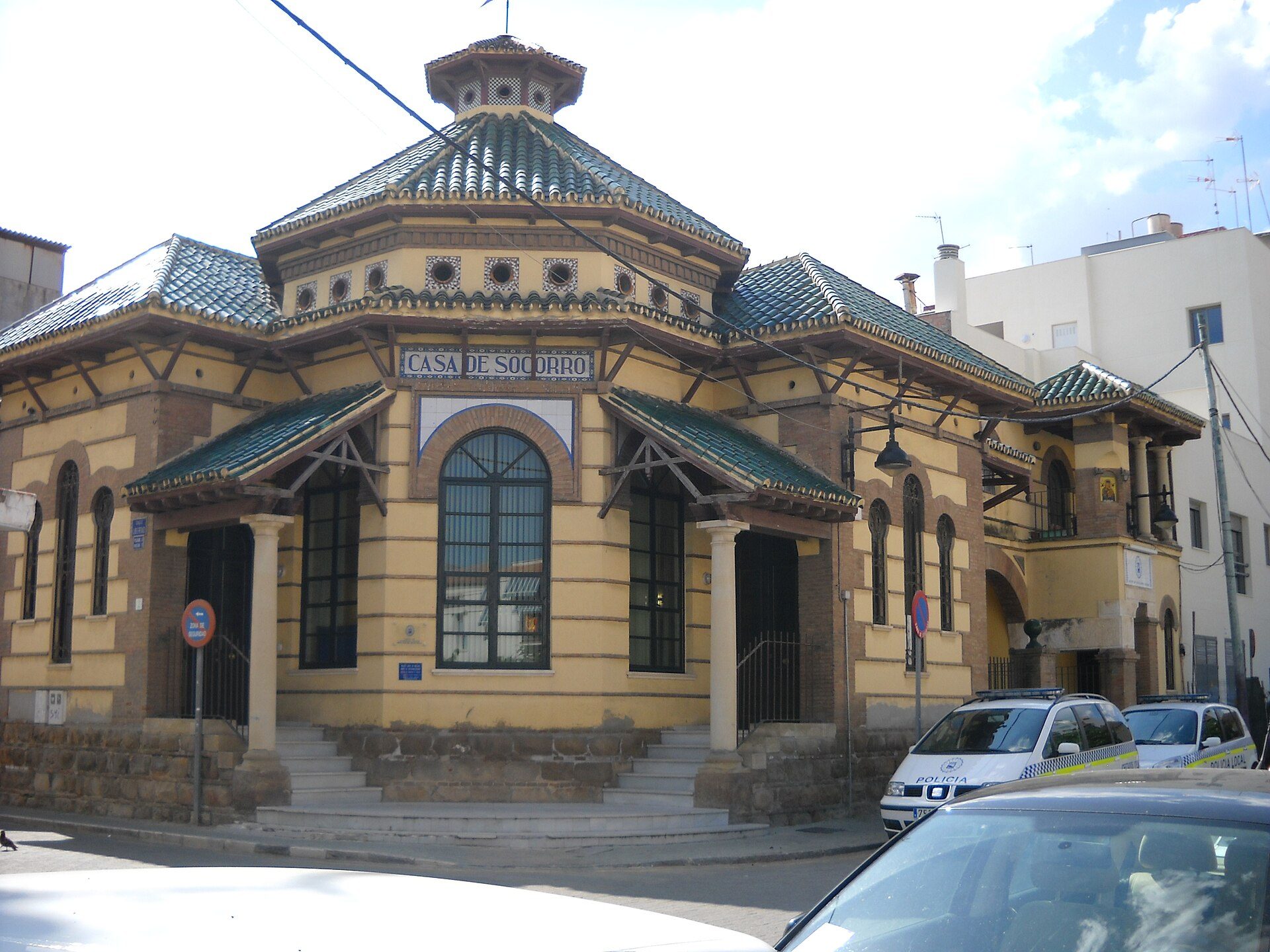 Traditional building with arched windows, green roof, and "Casa de Soho Ibiza" sign.