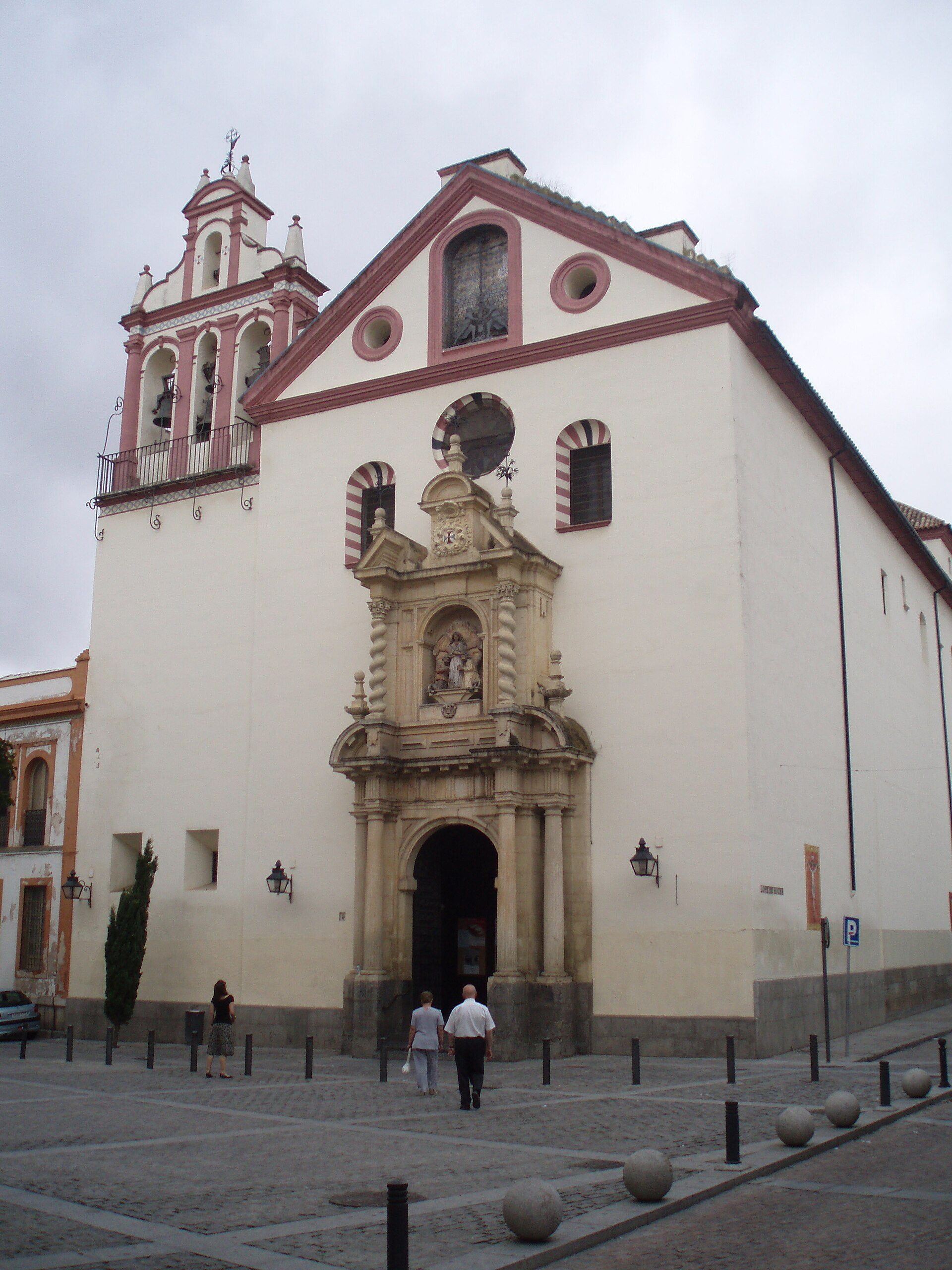 Alt text: Historic church with white facade, bell tower, and arched entrance.