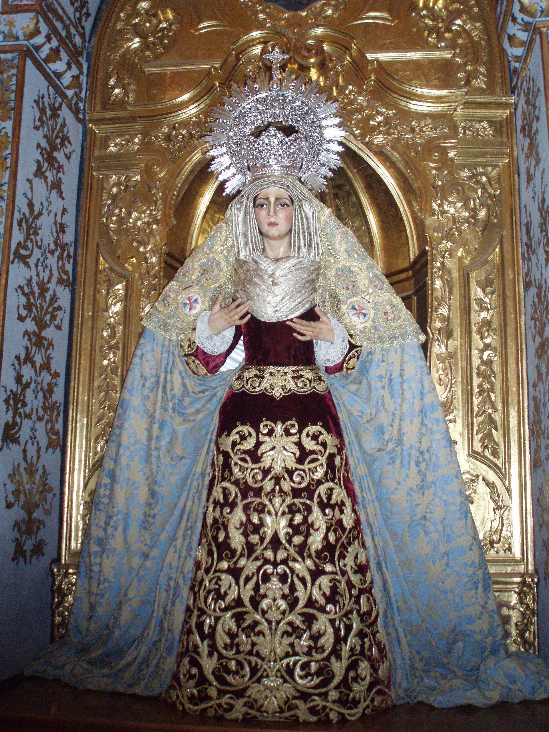Alt text: Ornate religious statue of a figure in a blue and gold robe, standing in a richly decorated alcove.
