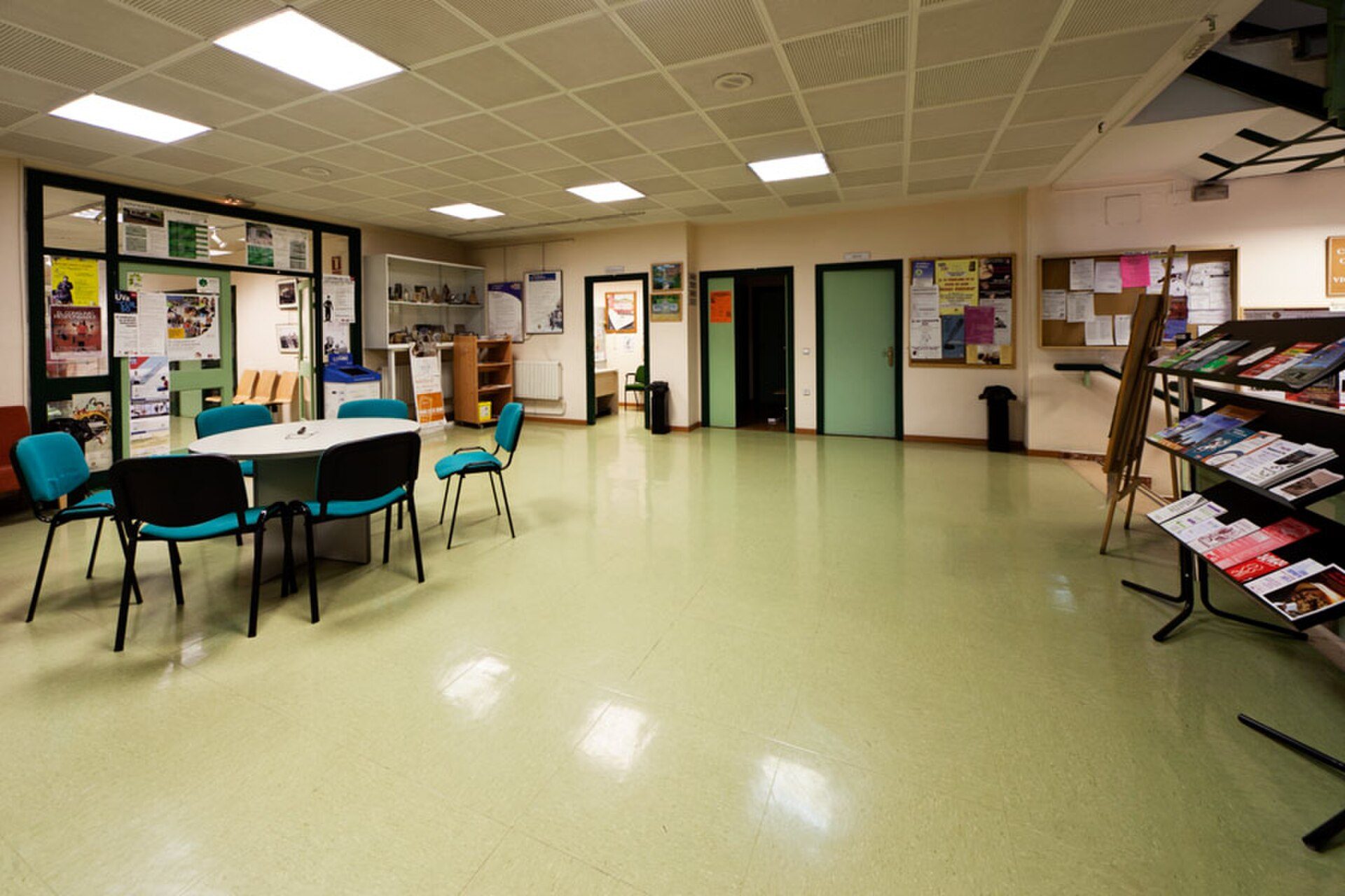 Community room with tables, chairs, bookshelves, and bulletin boards.