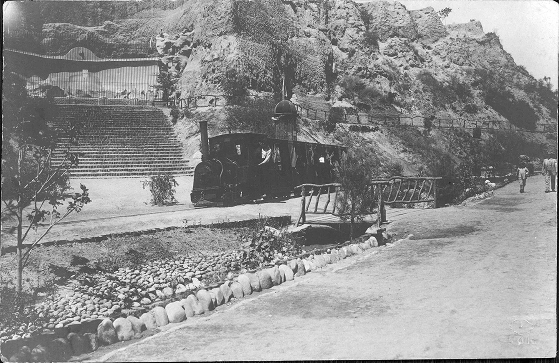 Alt text: Vintage photo of a small train on a hillside with steps and a pathway.