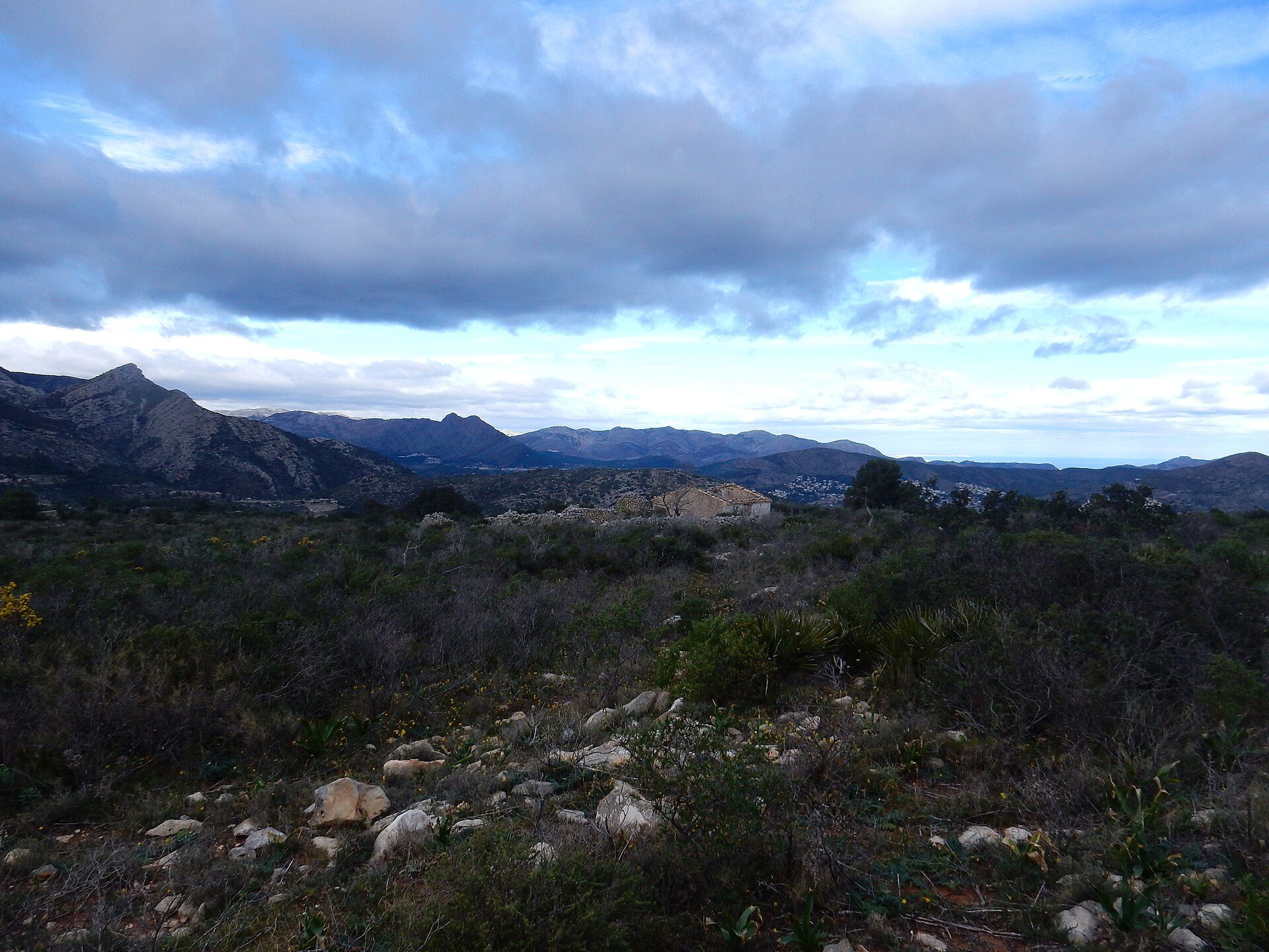 Alt text: "Mountain view room with rocky landscape and distant ocean.