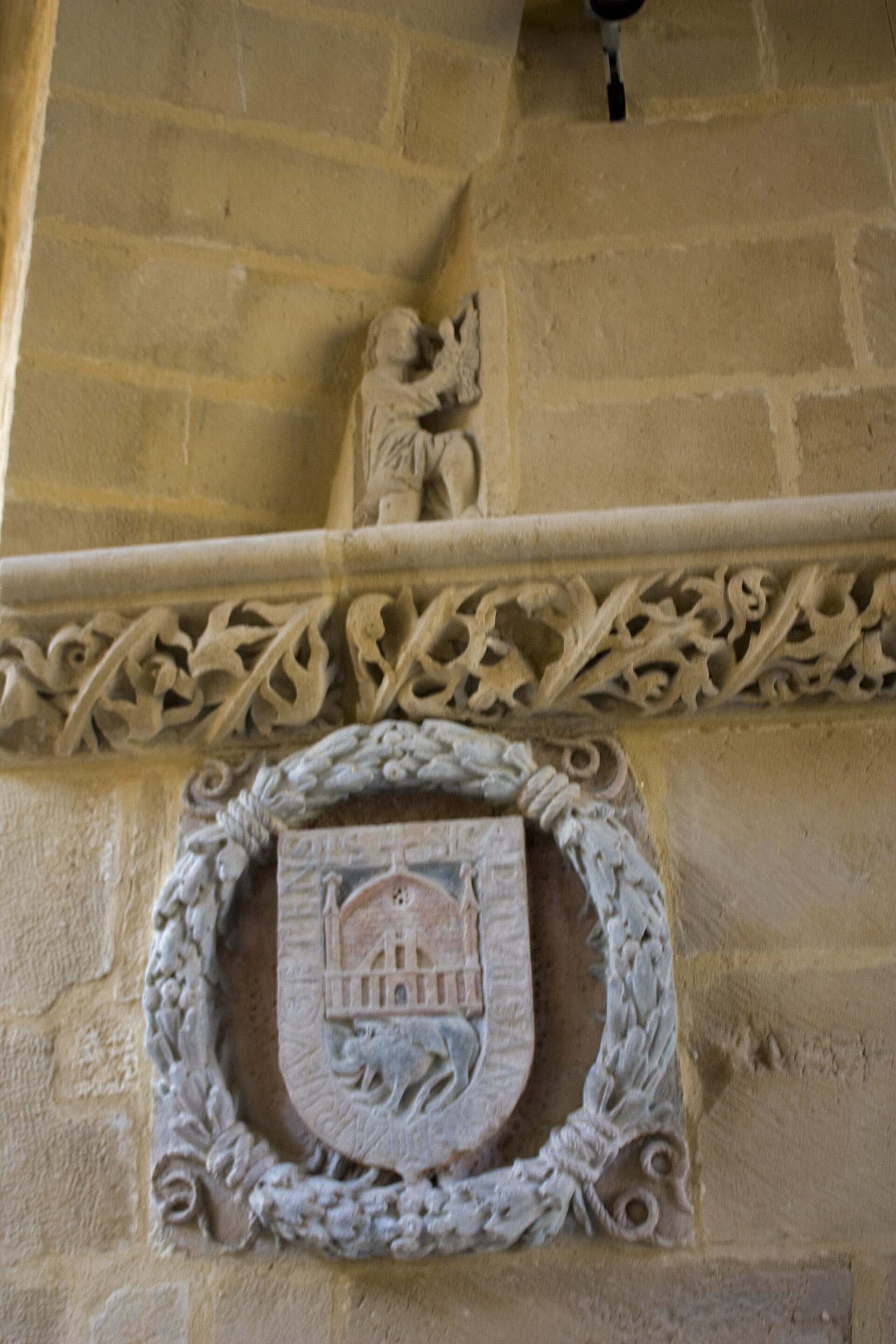 Alt text: Stone wall with carved emblem and relief sculpture.