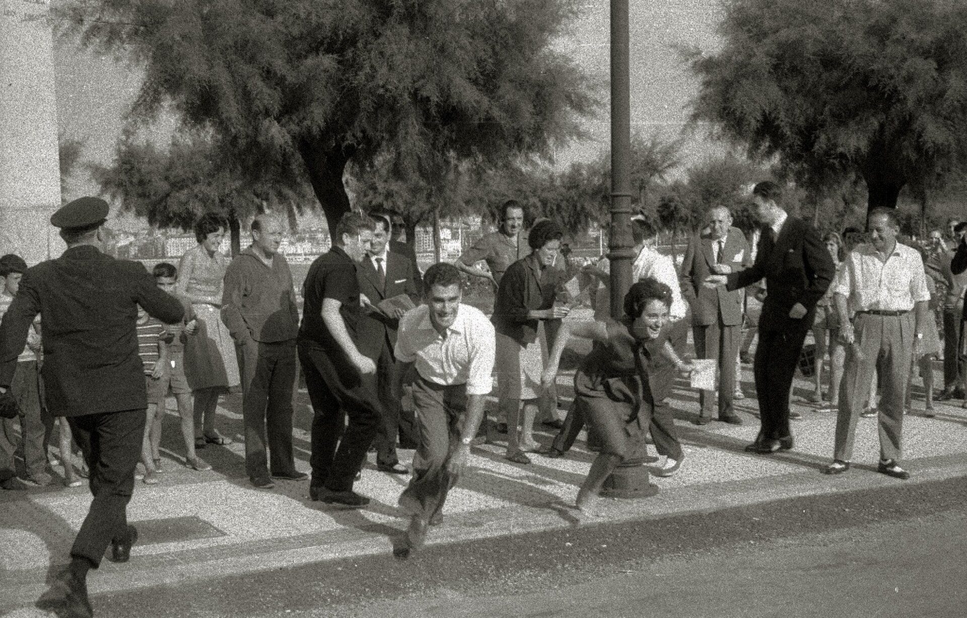 Alt text: Vintage black-and-white photo of people walking on a city street.