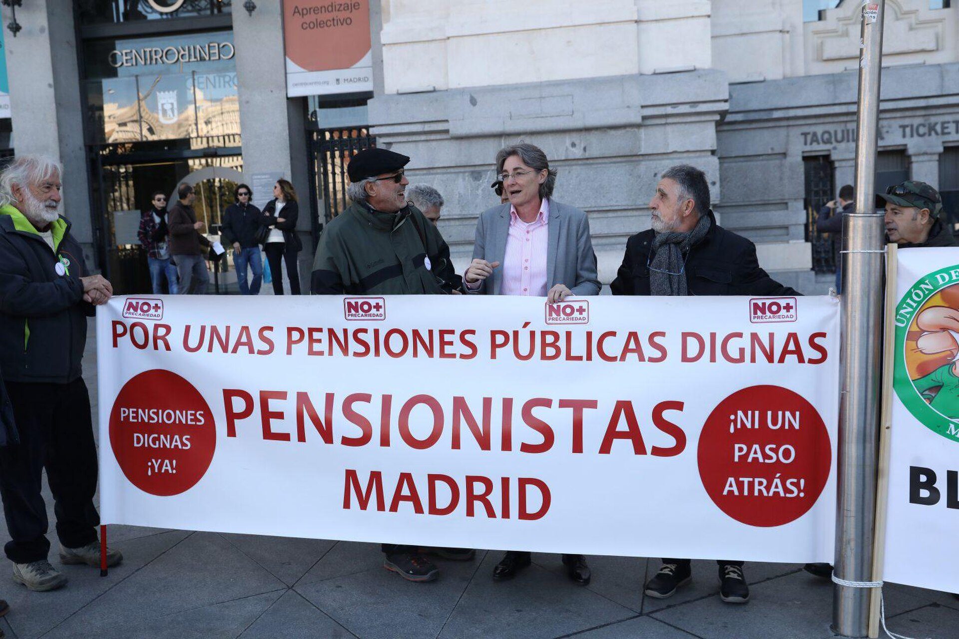A group of people holding a banner in front of a building.