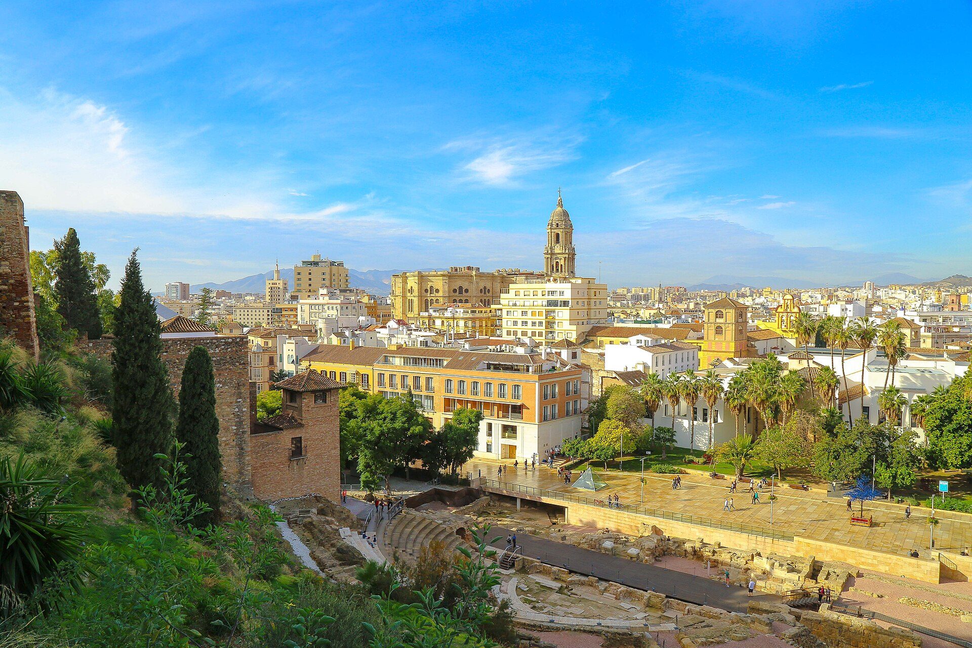 Panoramic city view from a spacious balcony with a mix of modern and historic buildings.